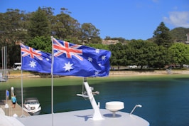 Australian flags fly over a beautiful harbor.