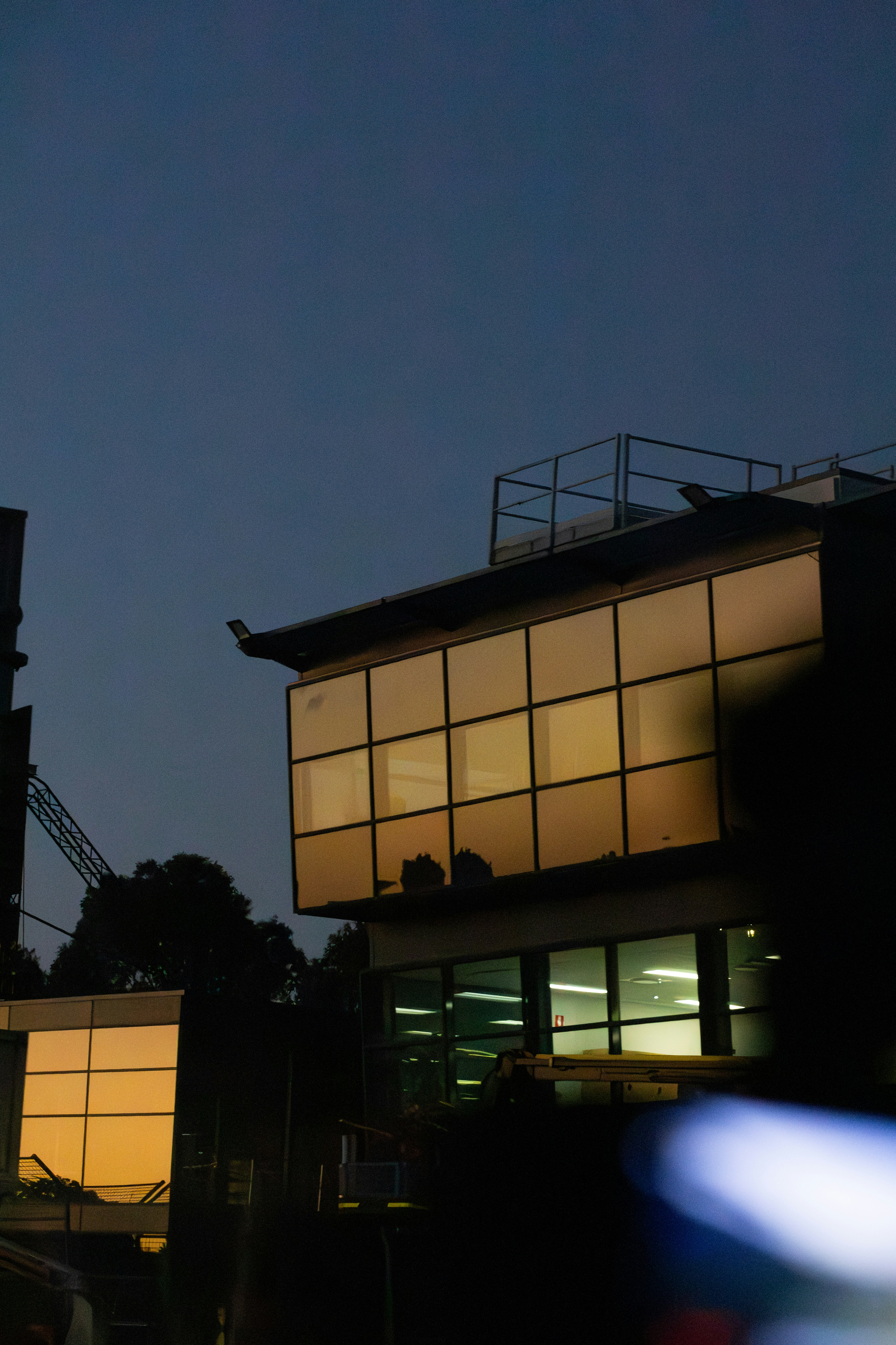 A modern building glows against the dusk sky.
