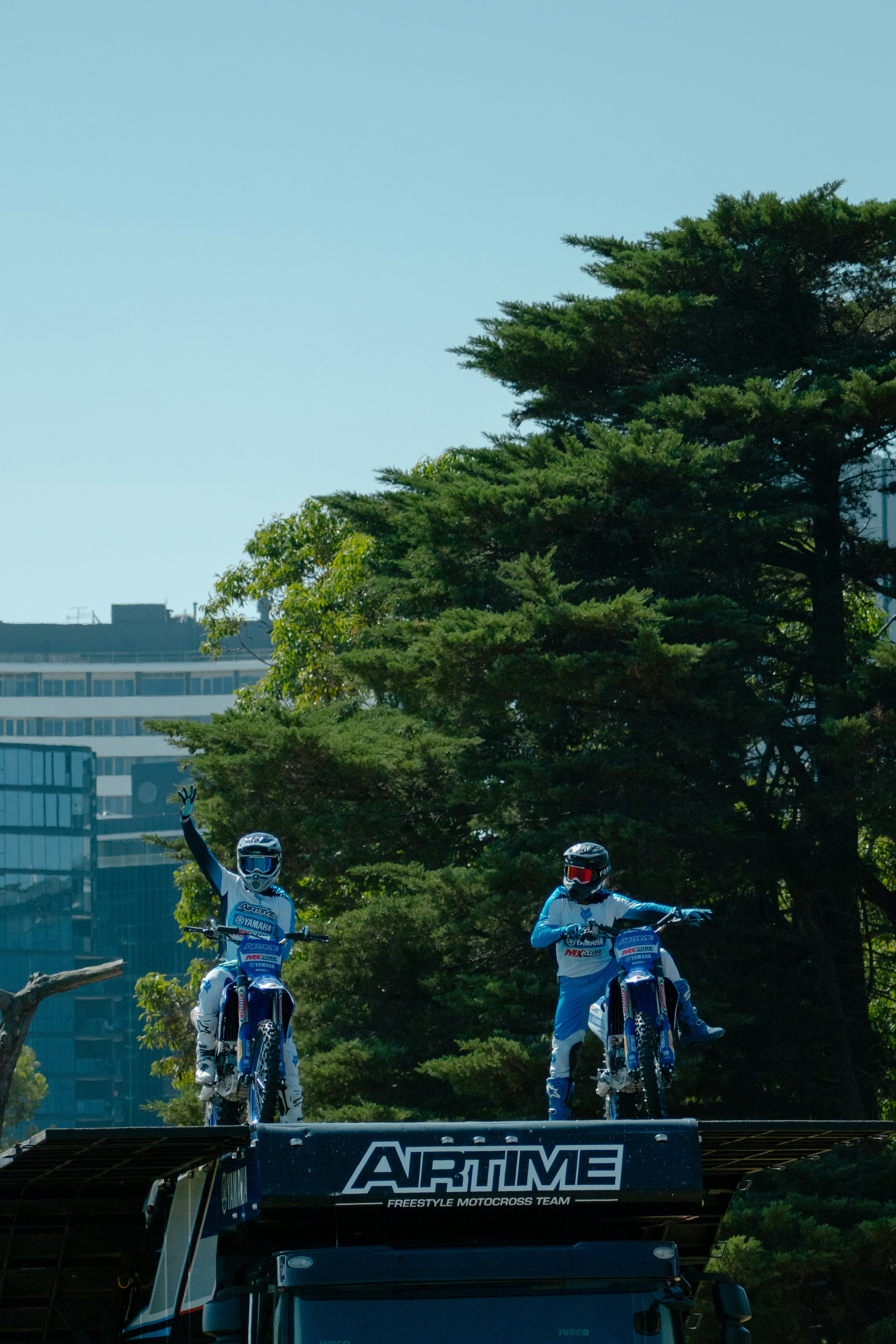 Two motocross riders prepare for a stunt.
