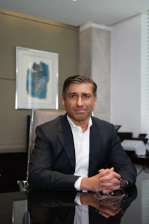 A man in a suit poses in an office.