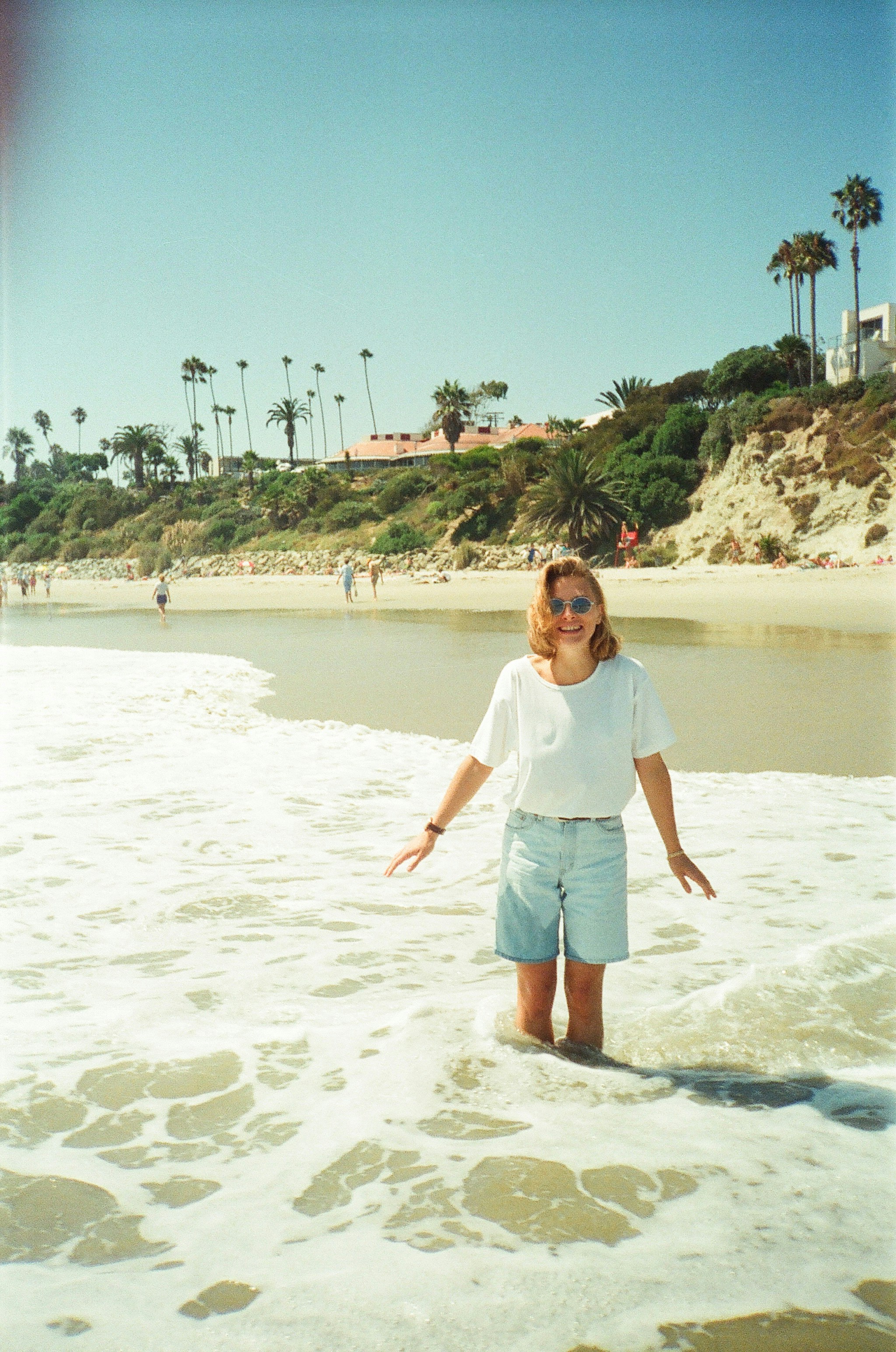 Frau genießt das Meer an einem sonnigen Strand.