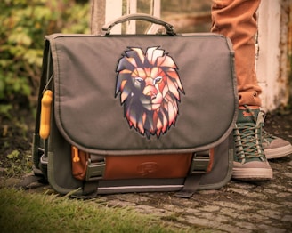 A schoolbag with a lion's head graphic.