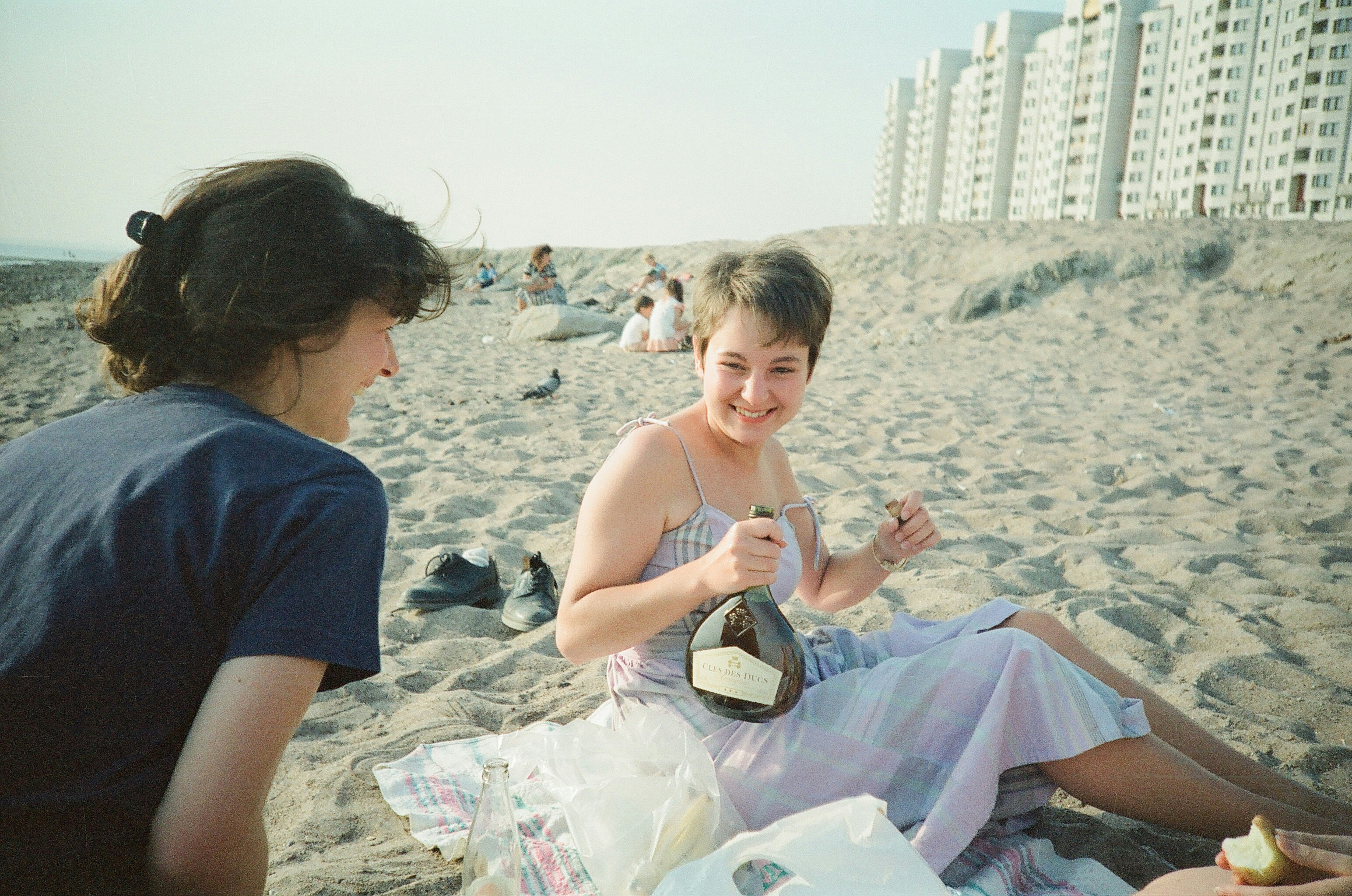 Friends celebrate with champagne on the beach.