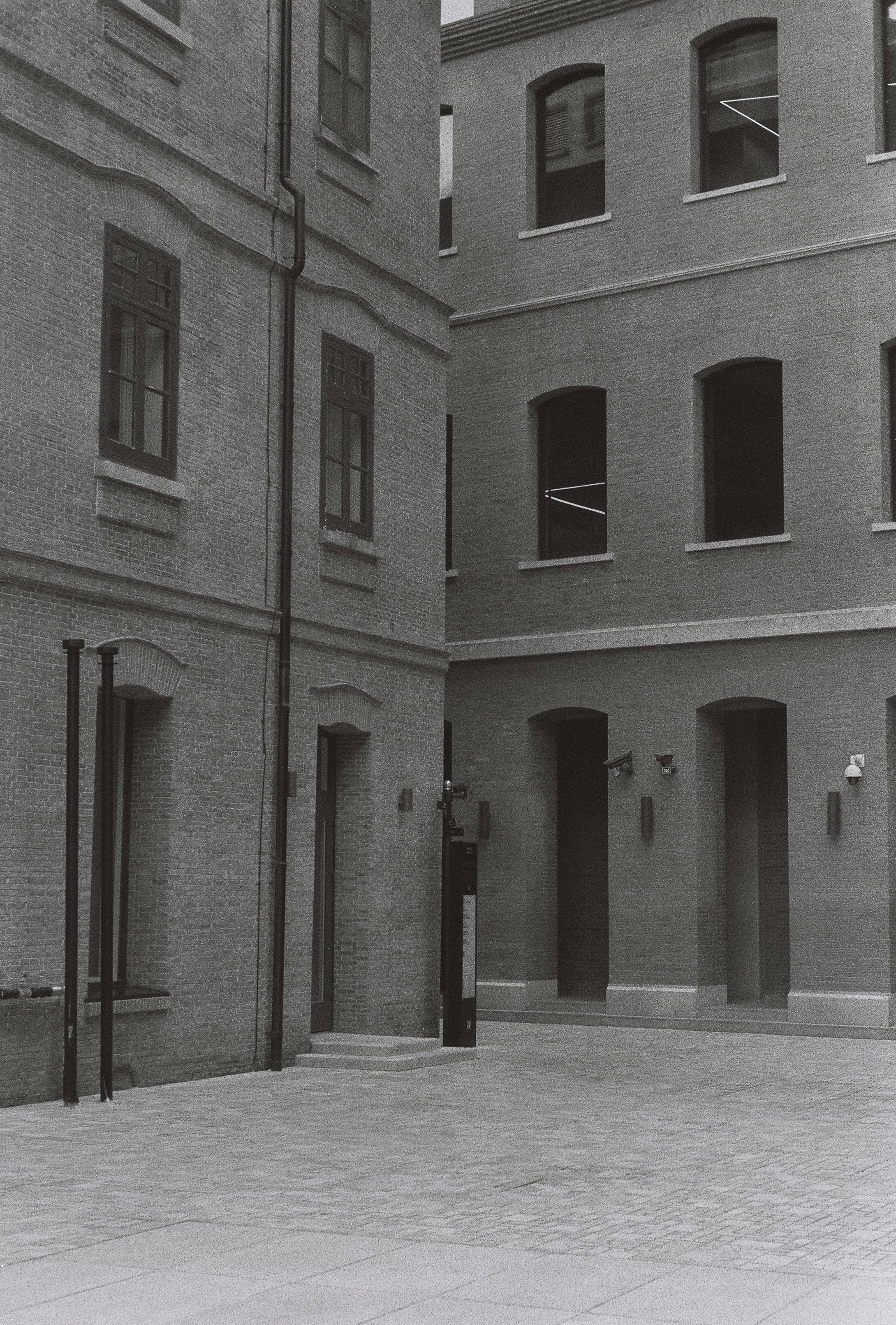 Les bâtiments créent une cour angulaire en noir et blanc.