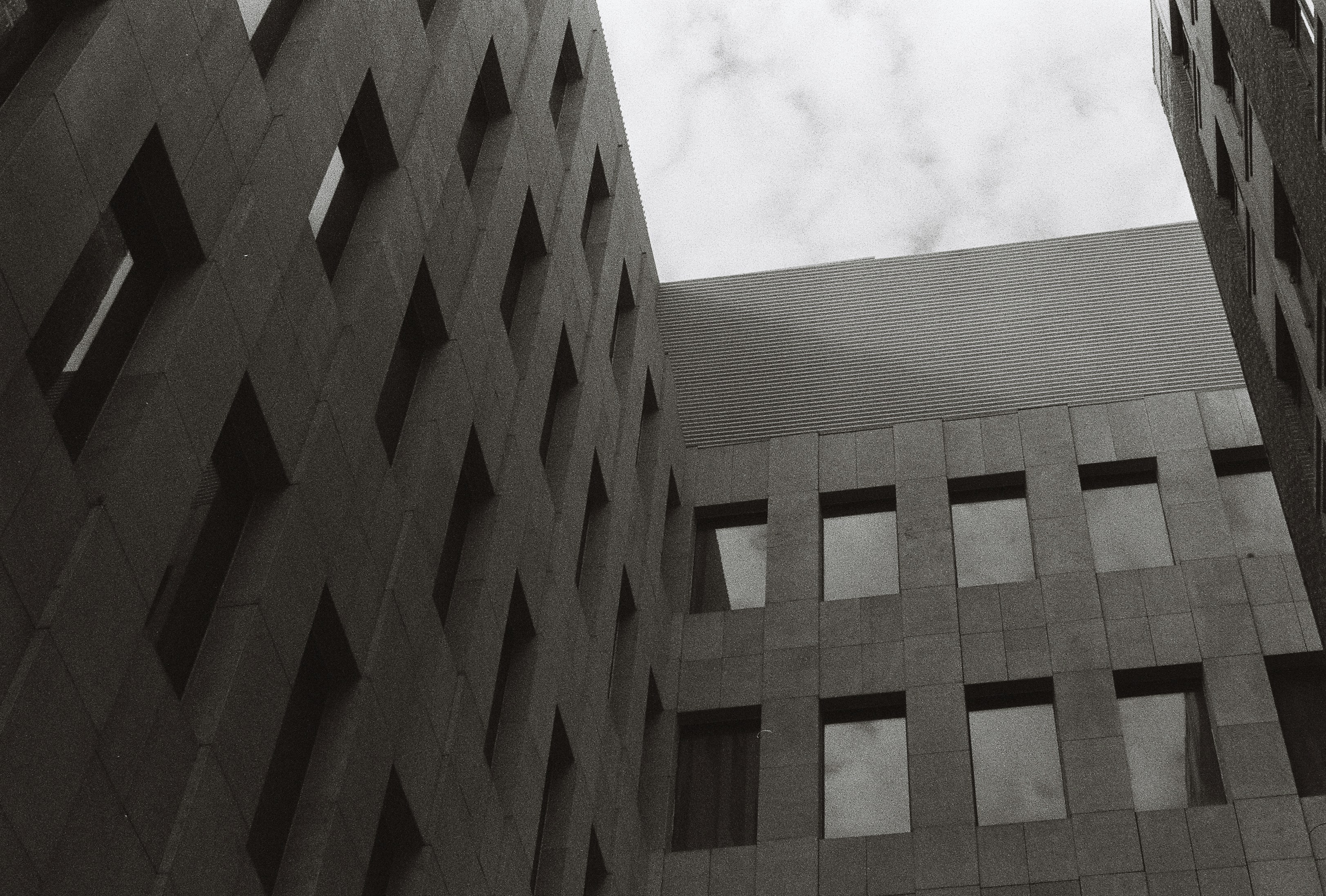 Un immeuble de grande hauteur avec des fenêtres rectangulaires regarde vers le haut.