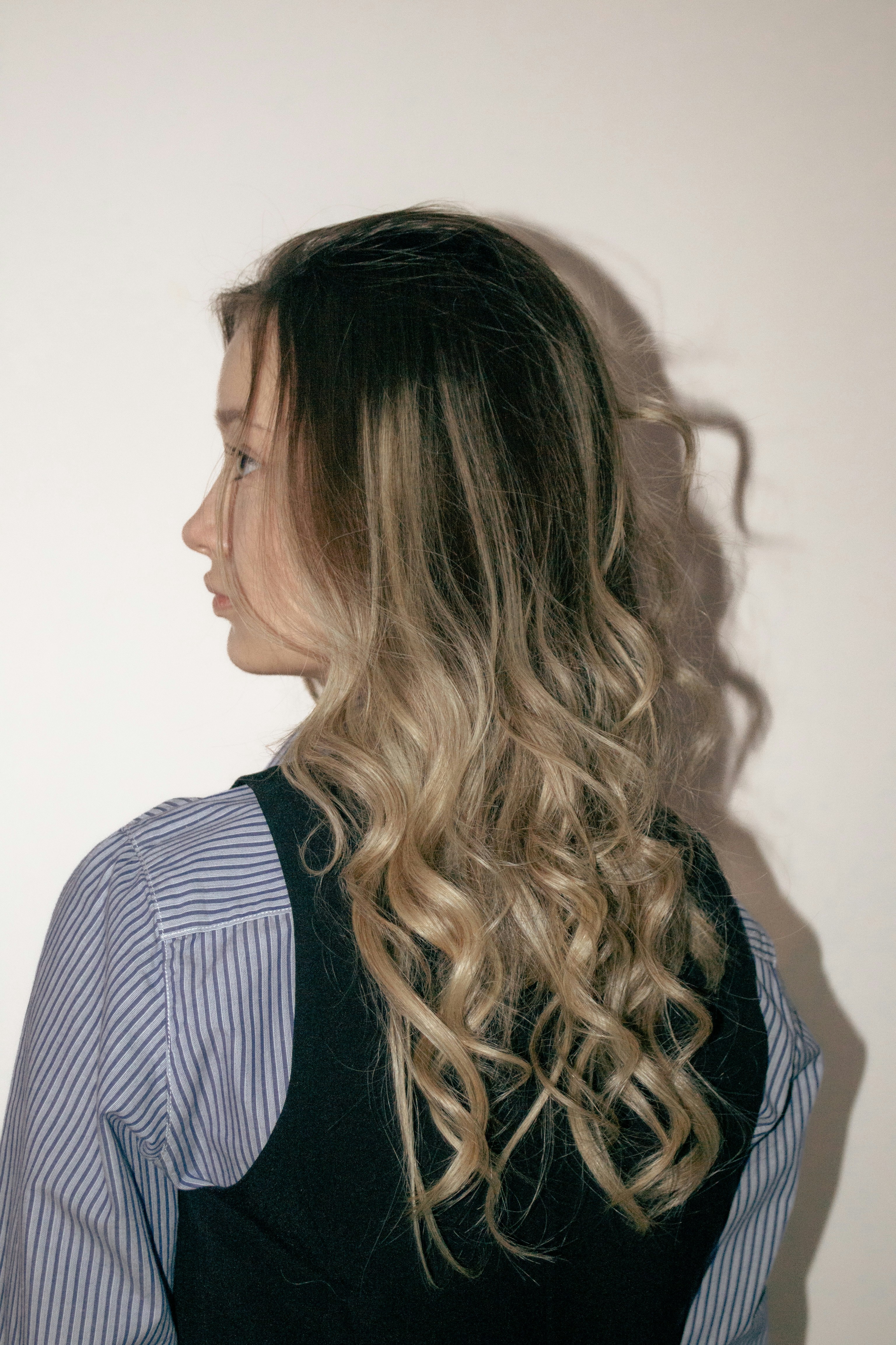 Blonde woman with loose curls styled using weft hair extensions.