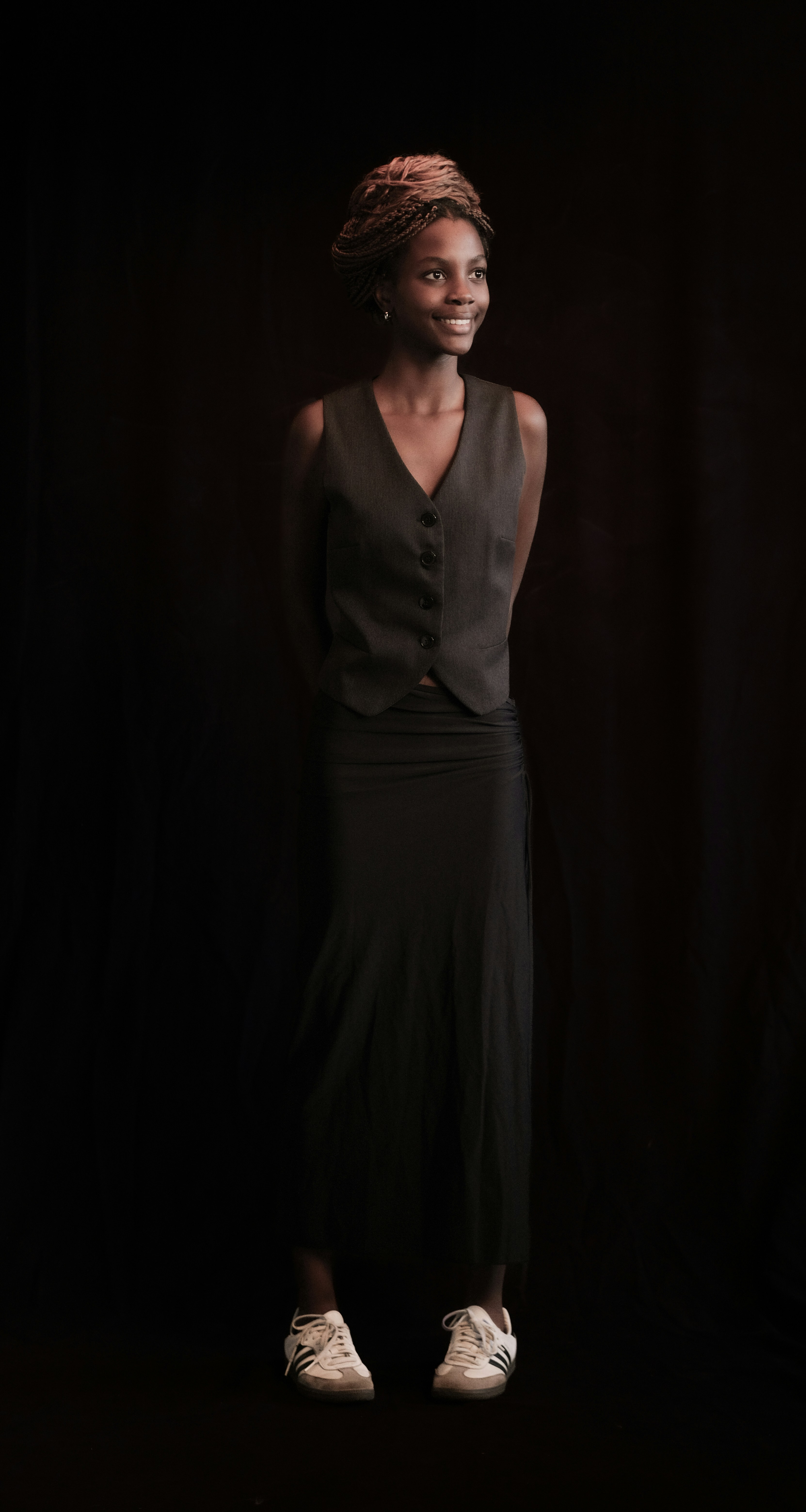 A woman poses in formal attire.