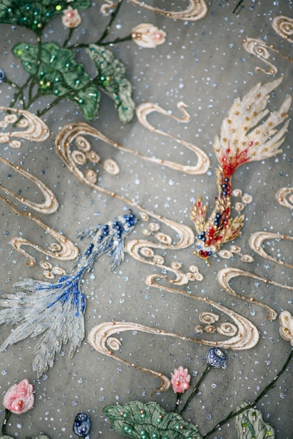 Embroidered fish swimming in a whimsical underwater scene, referencing the Tang Dynasty zoological motifs that inspired this bag's colourway names
