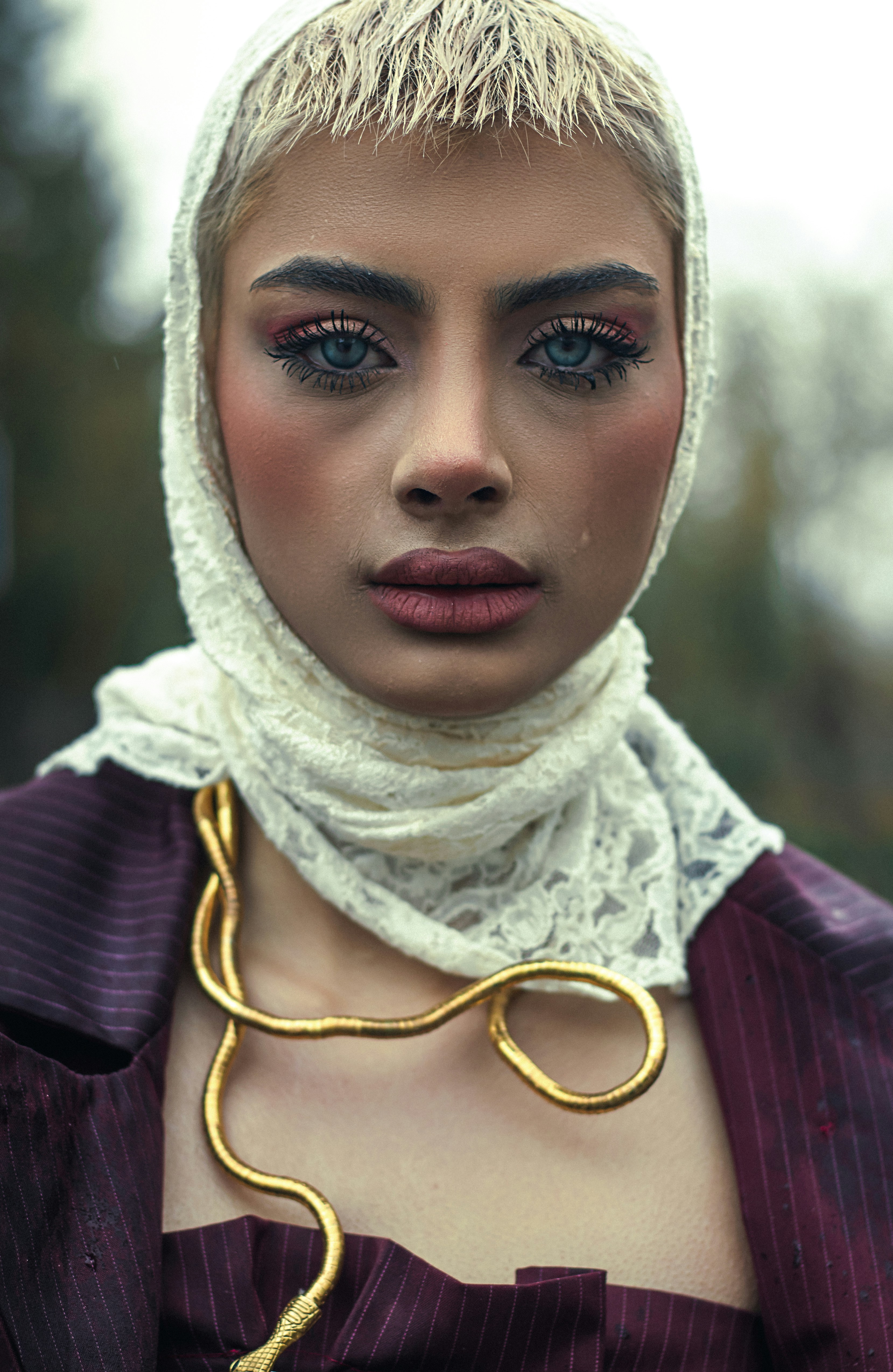 A woman with striking eyes and gold jewelry.