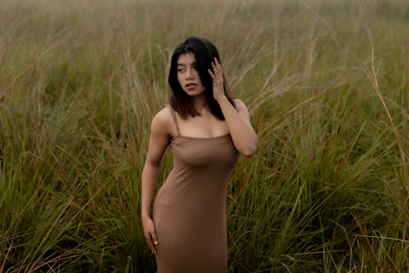Woman in a dress poses in a field.