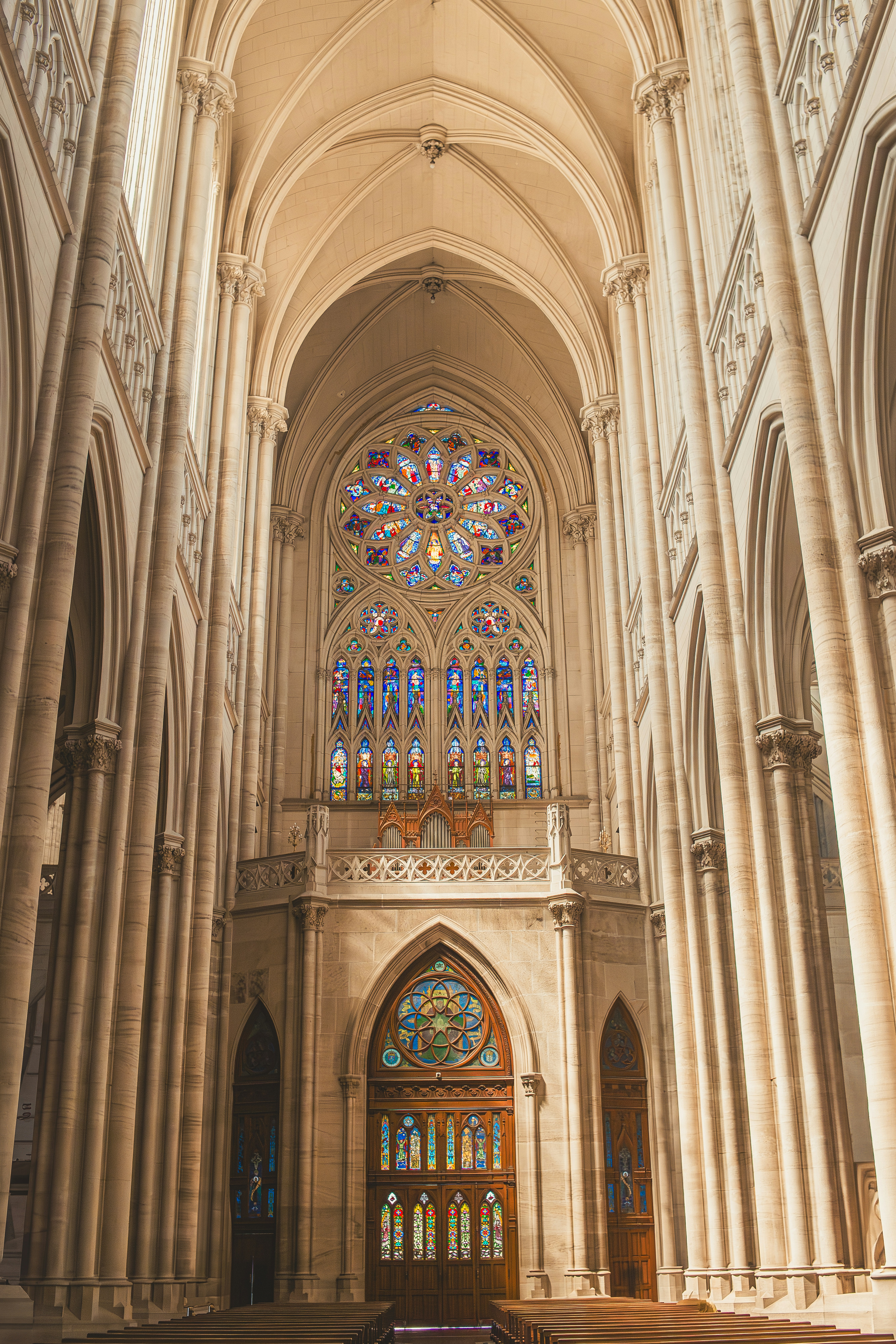A tall church interior features stained glass.