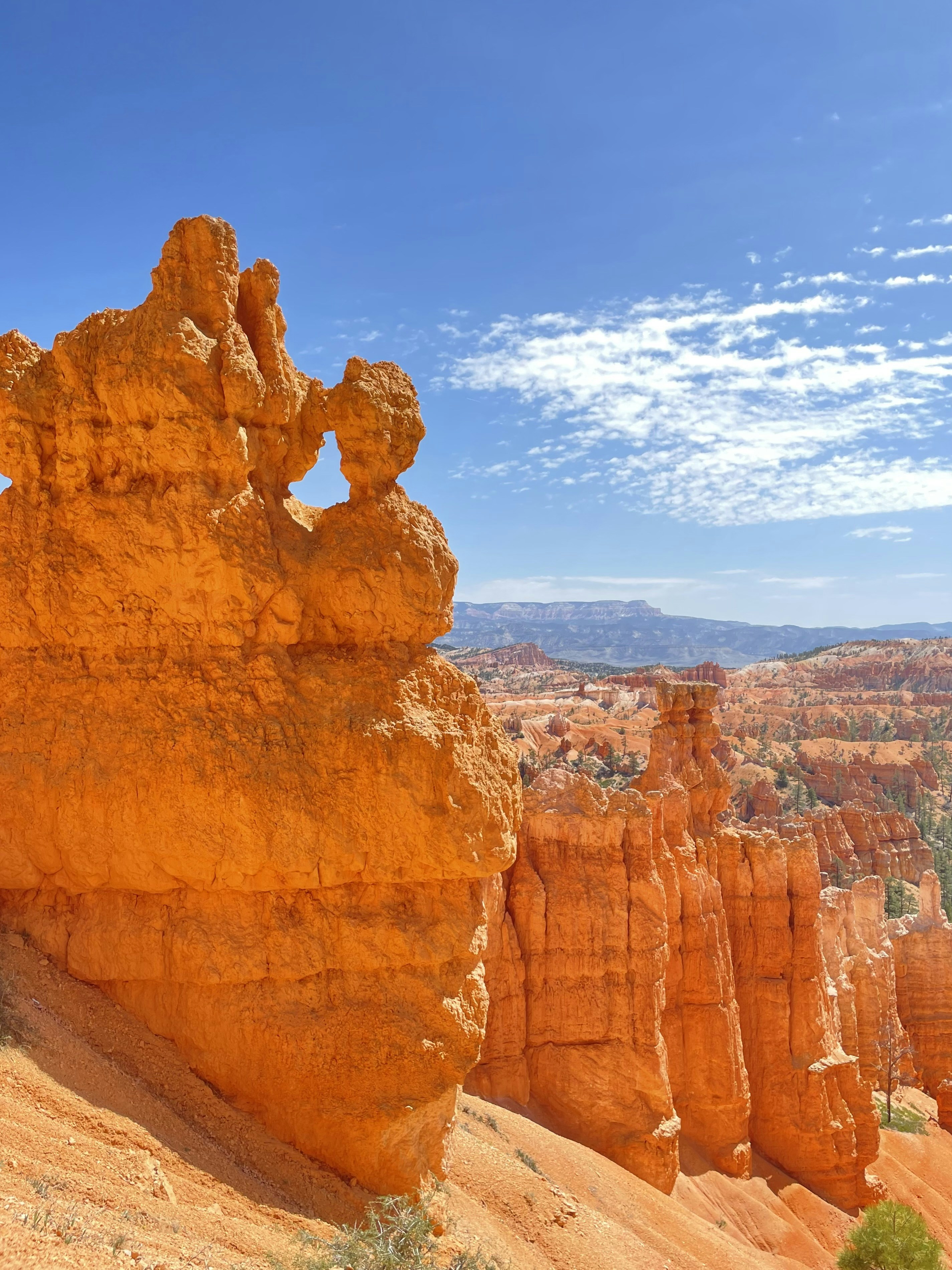 Rote Felsformationen ragen unter blauem Himmel empor.