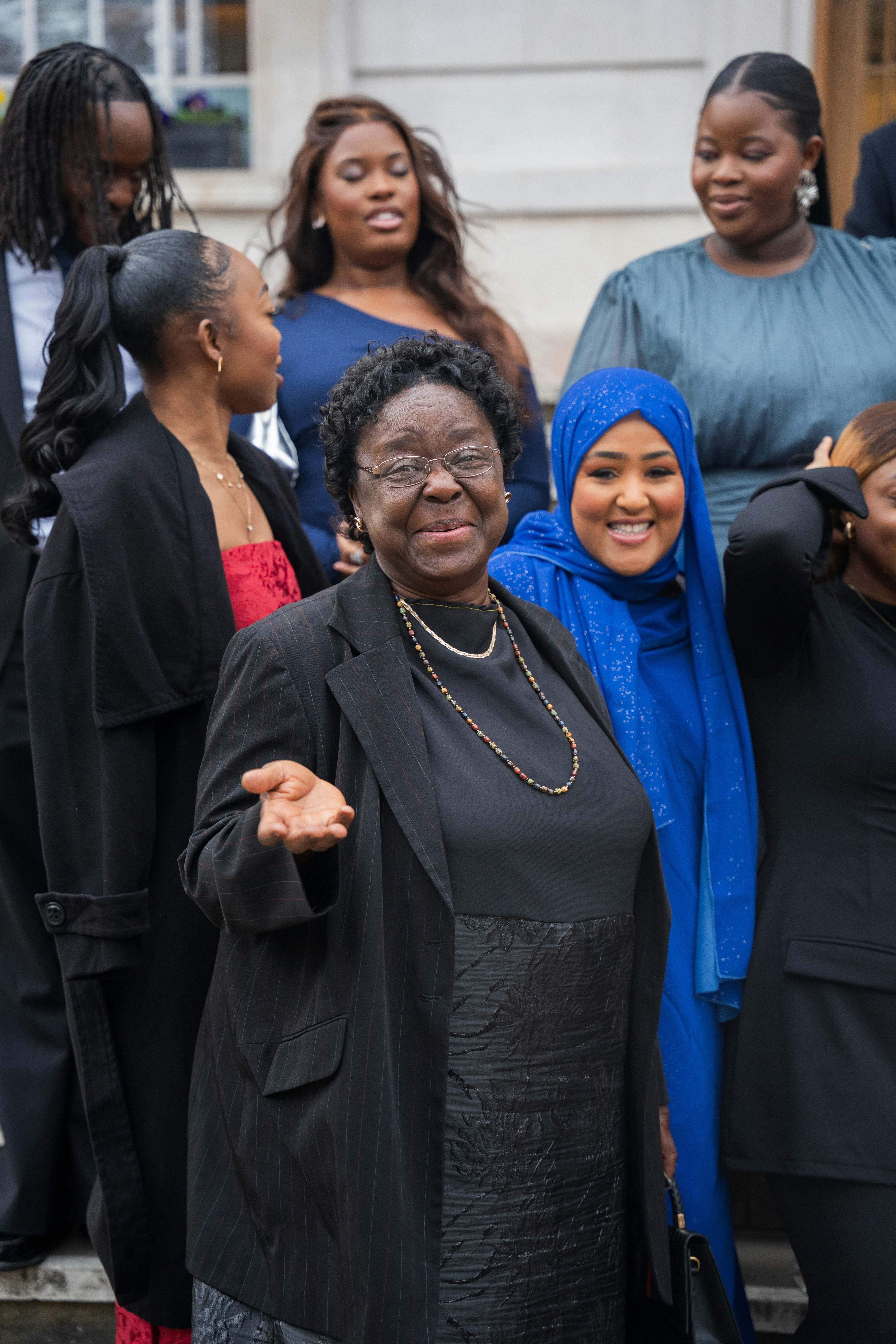 A group of diverse people smile for the camera.