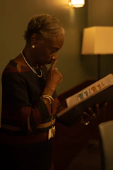 A woman looks thoughtfully at a binder.