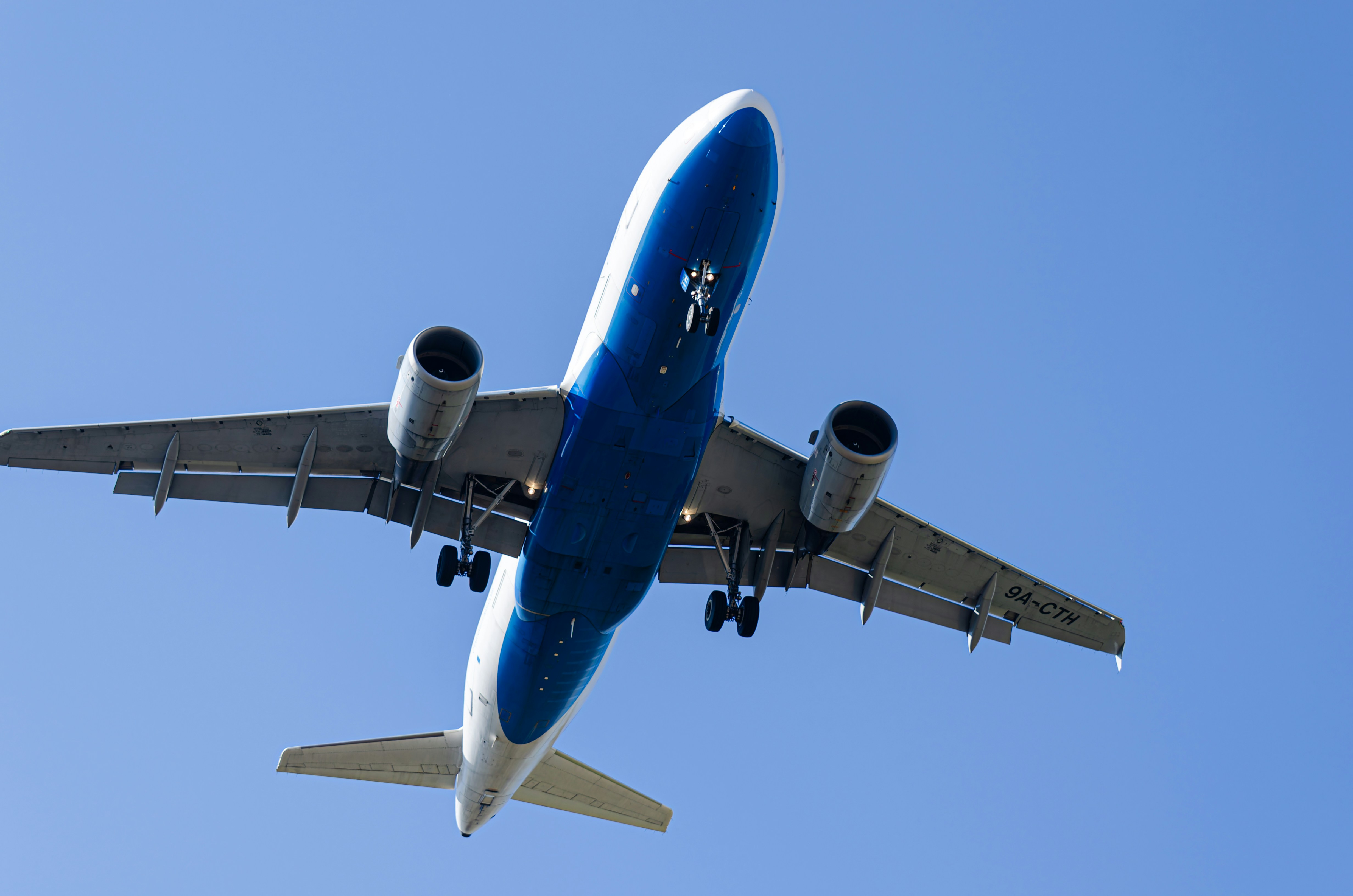 An airplane soars through the blue sky., Croatia Airlines Airbus A319 landing at Zagreb Airport.