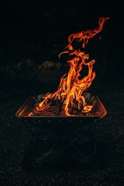 Flames dance brightly in a small fire pit.