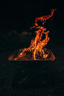 Flames dance brightly in a small fire pit.