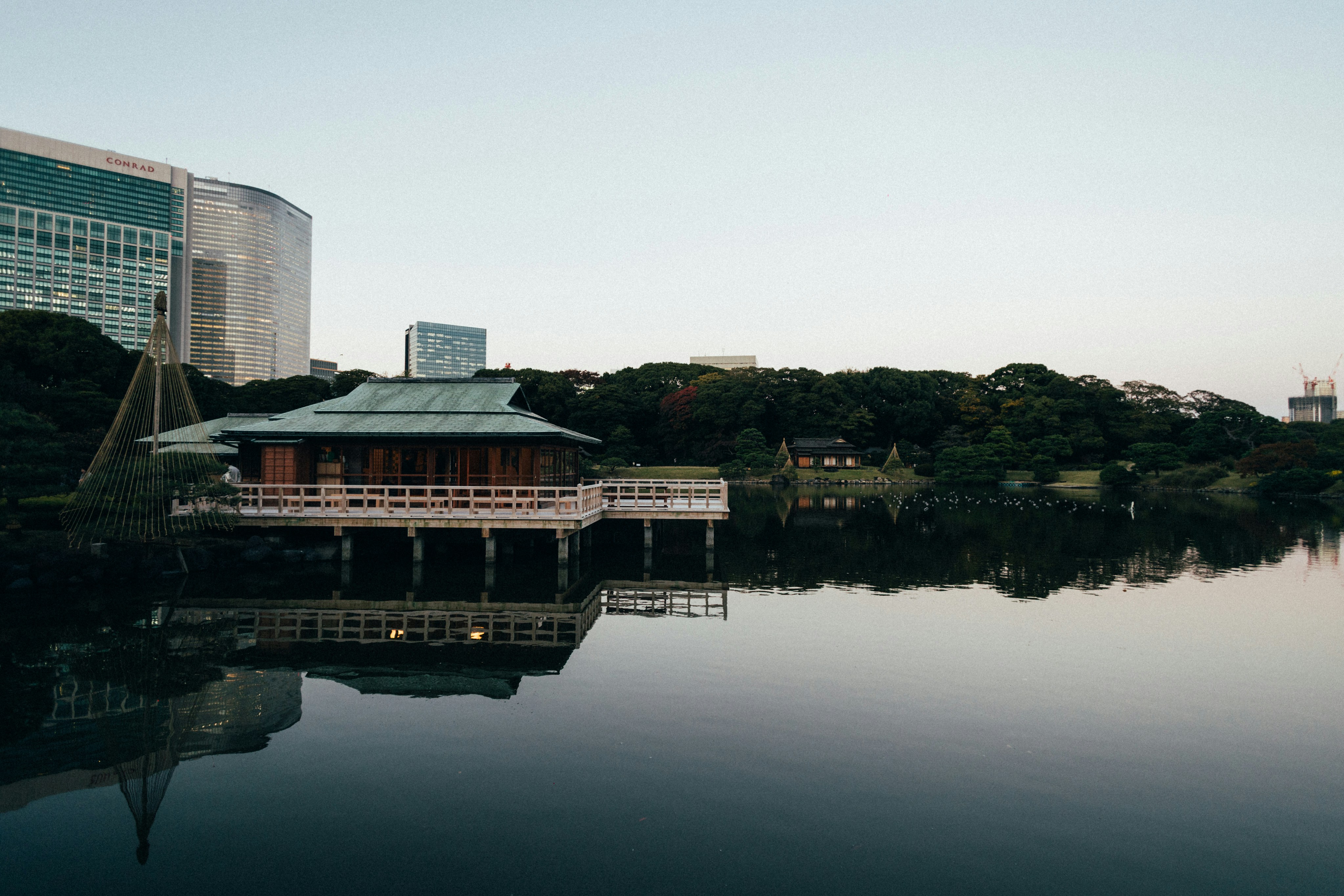 A japanese building reflects in still water.