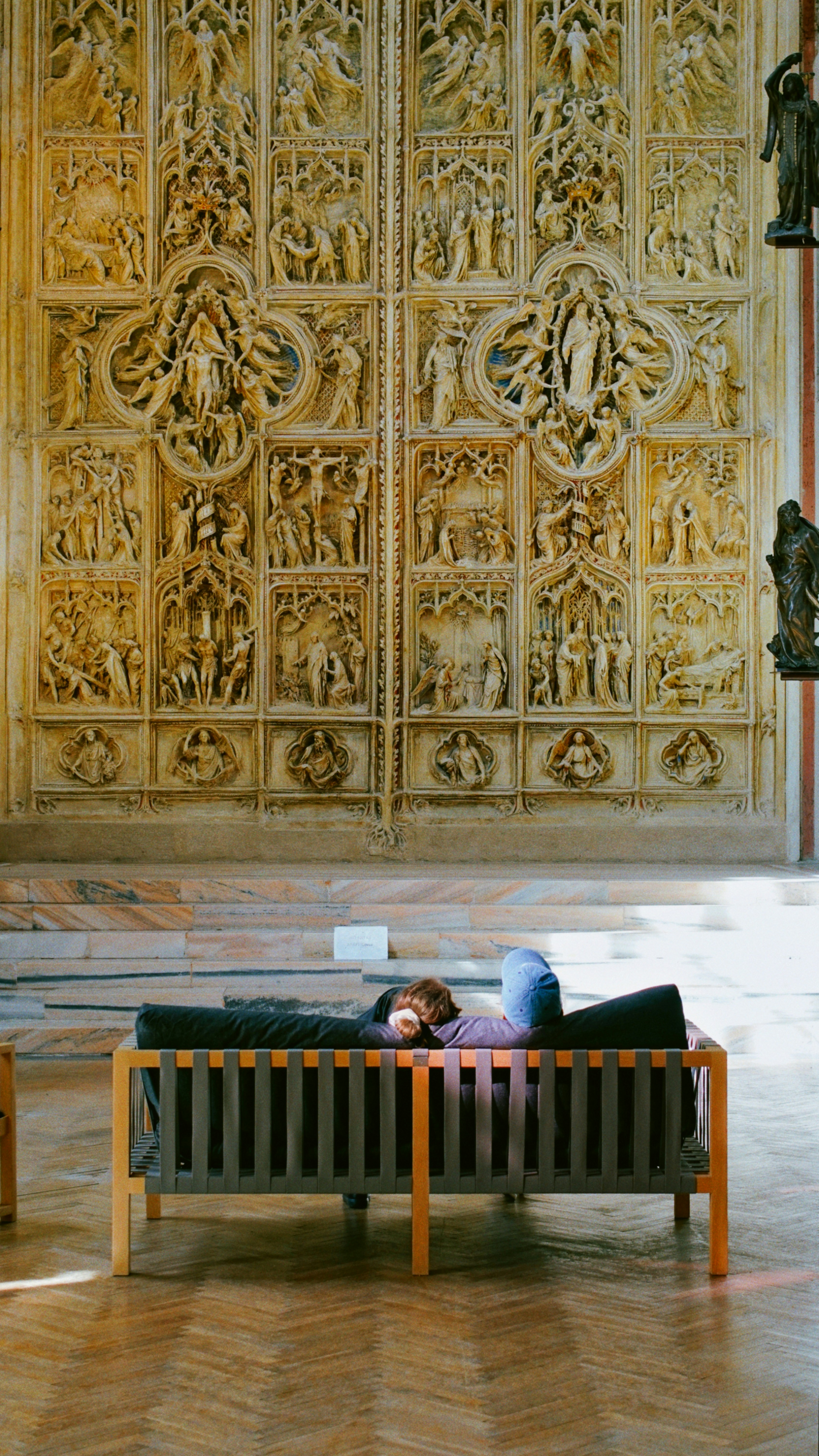 Person resting on a couch in a church.