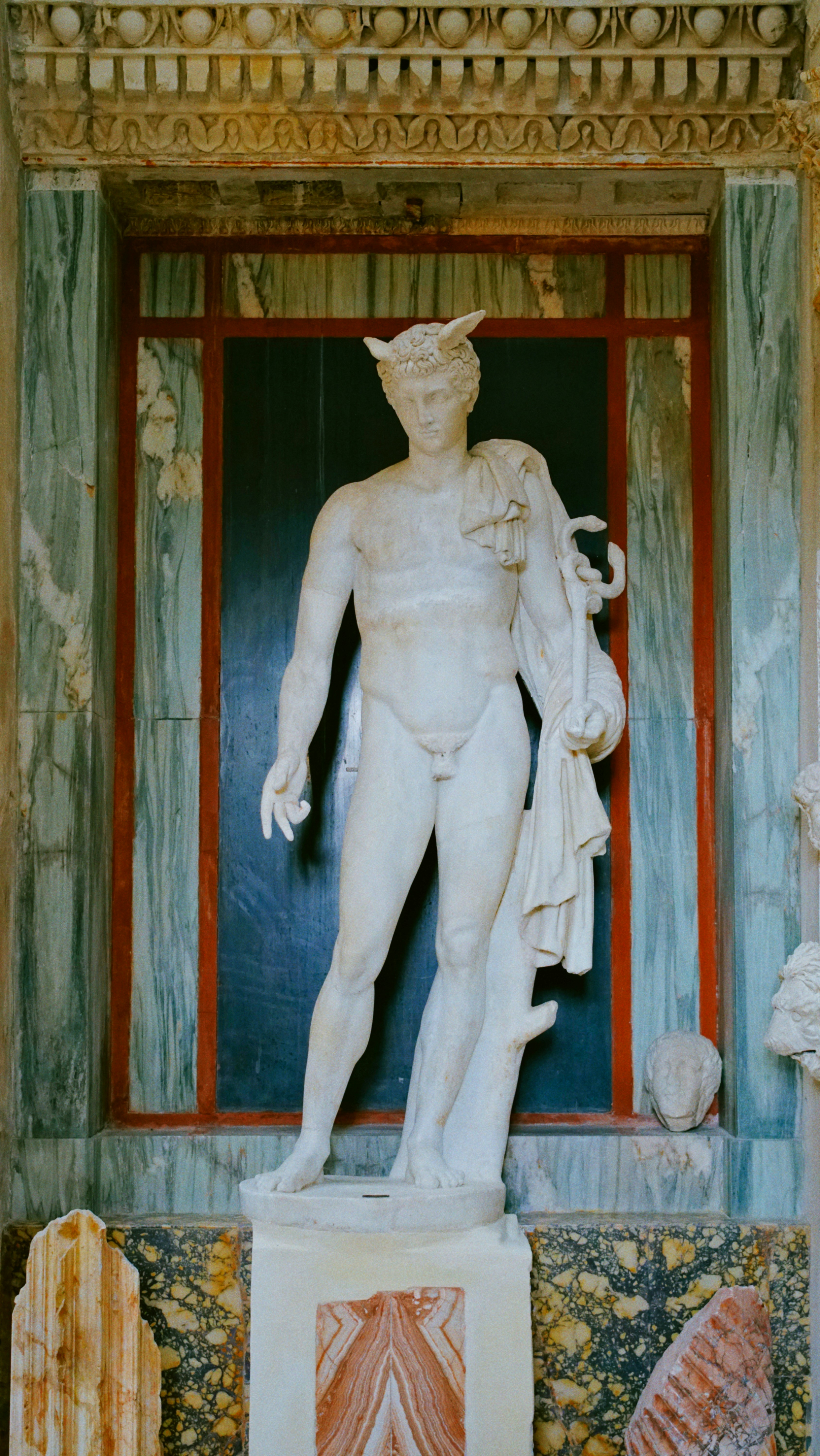 A marble statue of the roman god mercury.