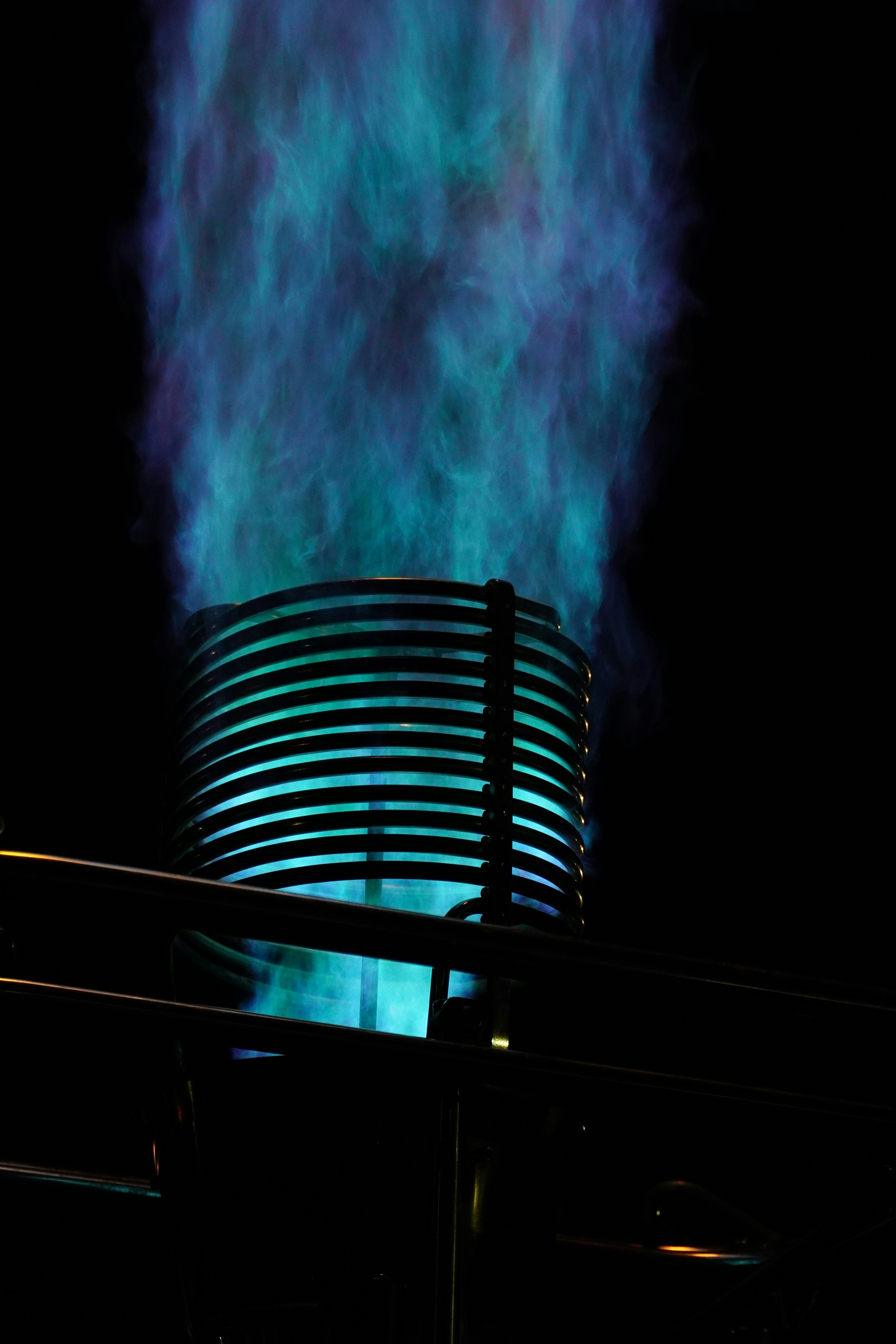 Blue flames erupt from a metal cylinder.