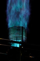 Blue flames erupt from a metal cylinder.