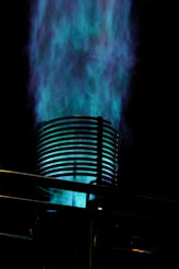 Blue flames erupt from a metal cylinder.