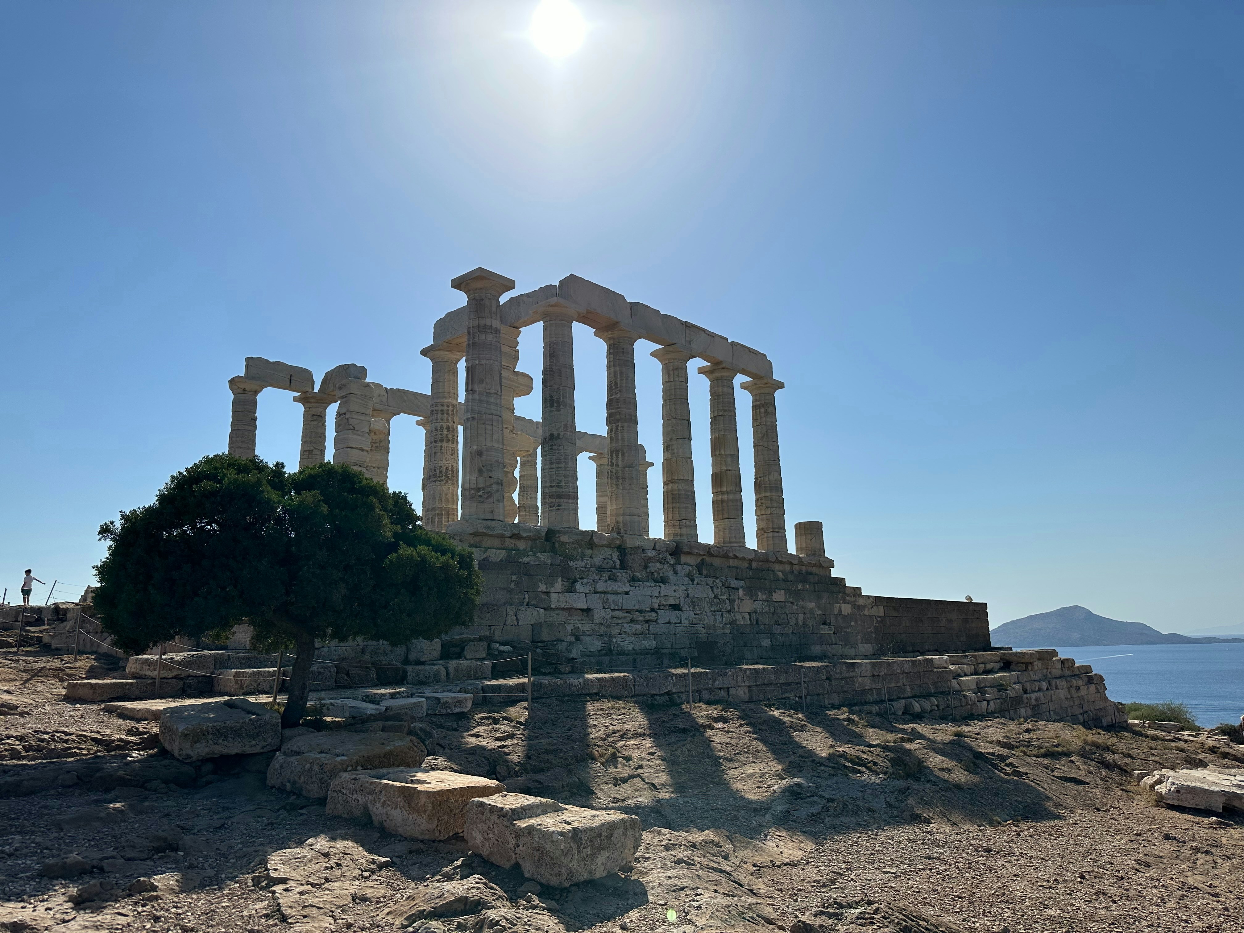 Ancient greek temple under a bright, sunny sky.