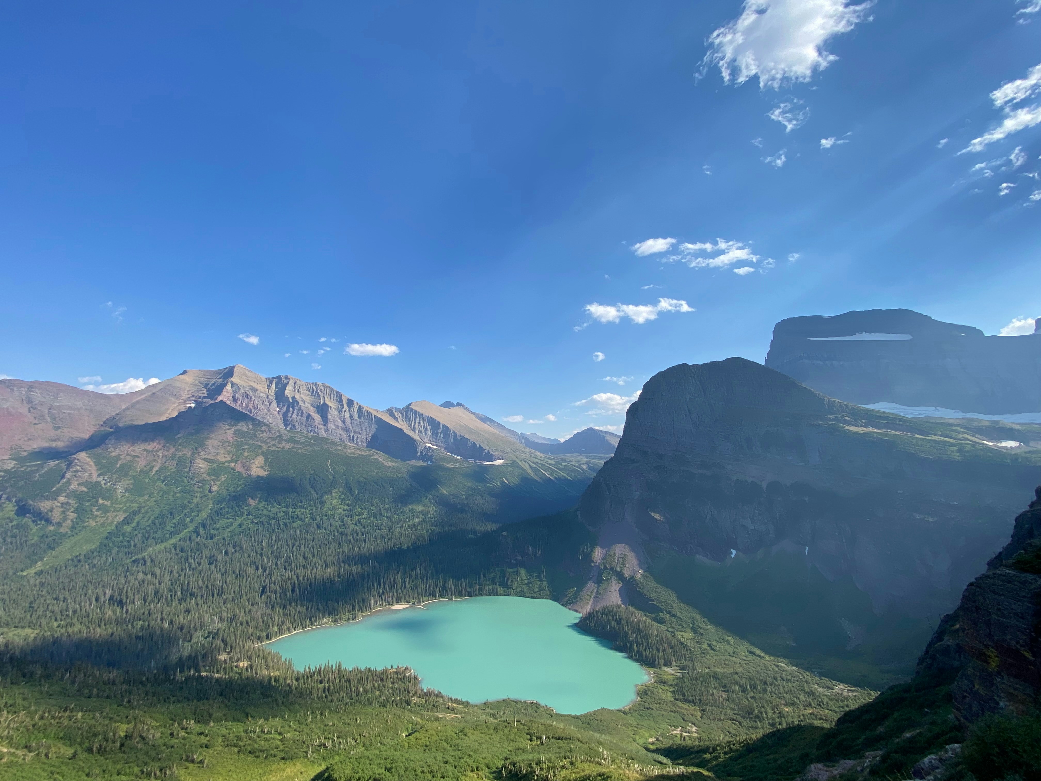 Mountains and a vibrant blue lake under a blue sky.