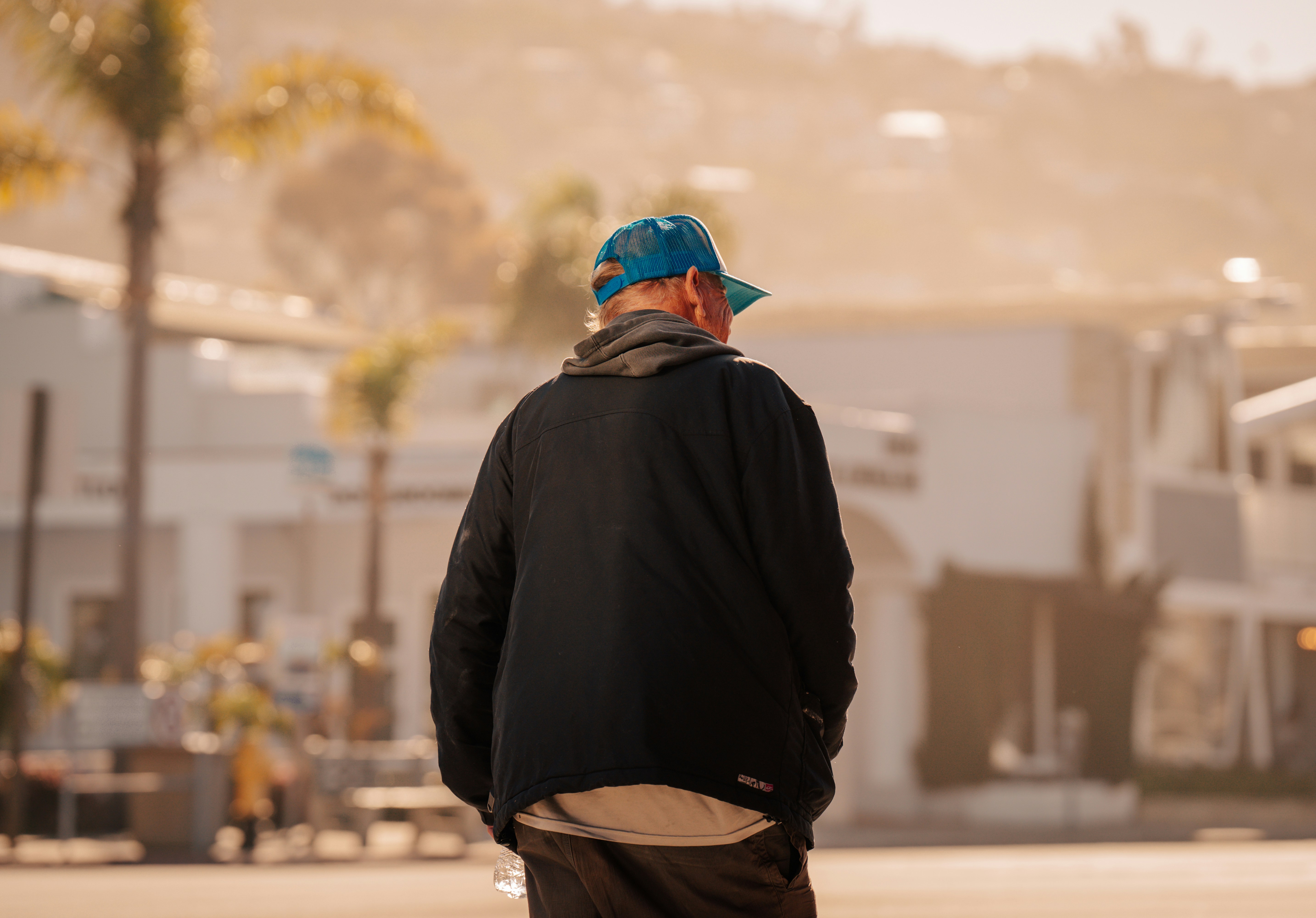 A man walks away on a sunny day.