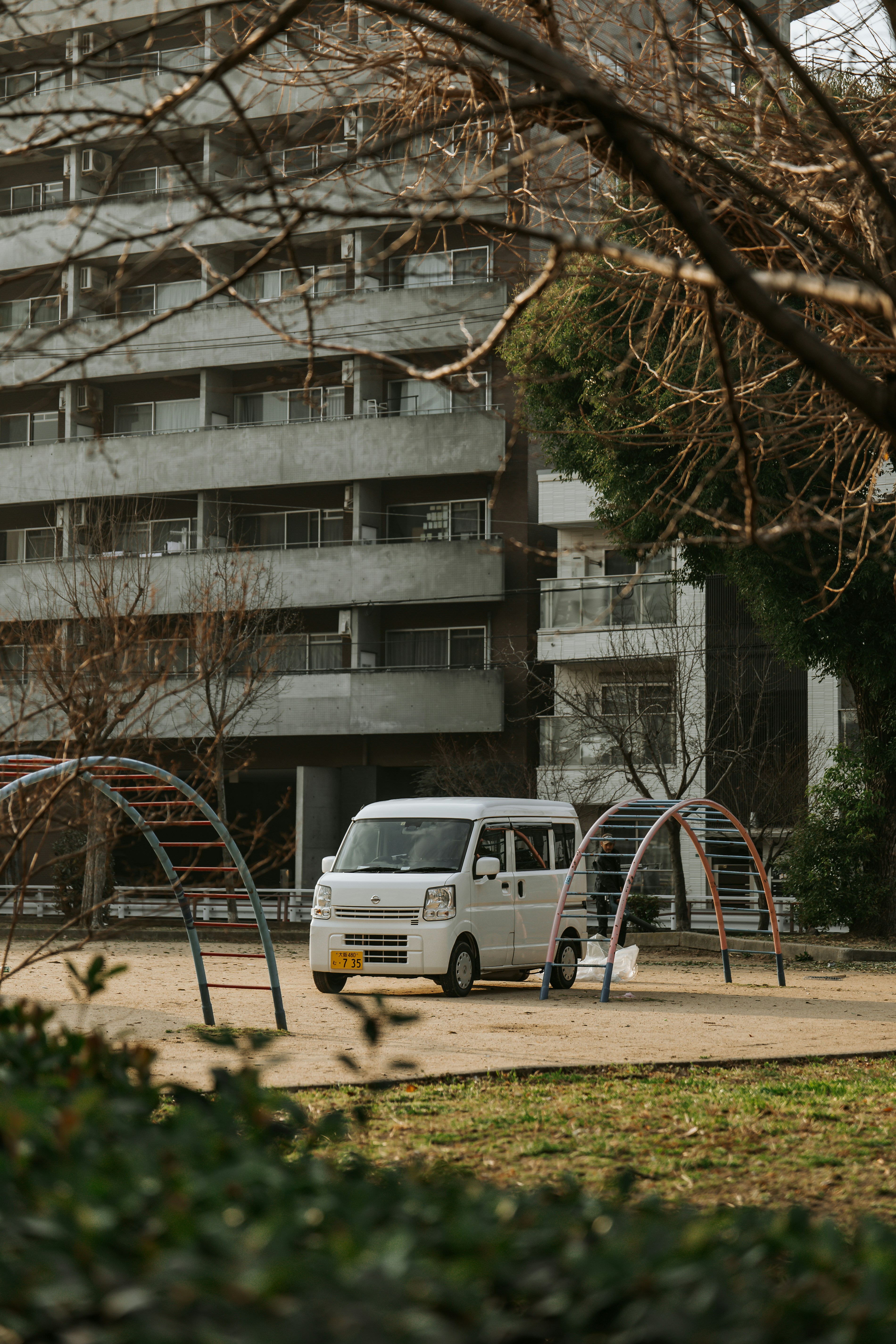 A white van parks beside a playground.
