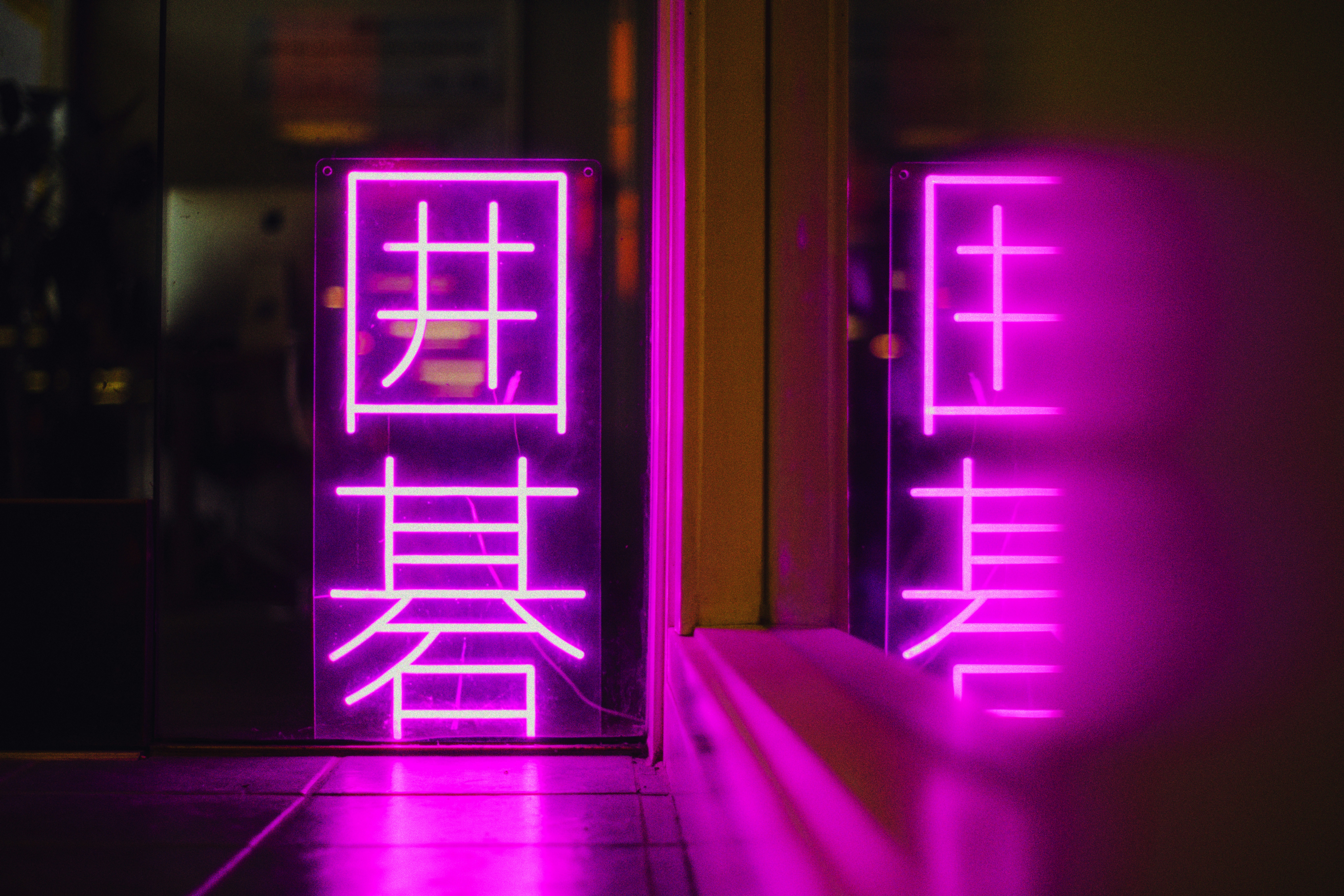 A glowing neon sign reflects in the glass. photo – Free Light Image on  Unsplash, image size:3000x2001