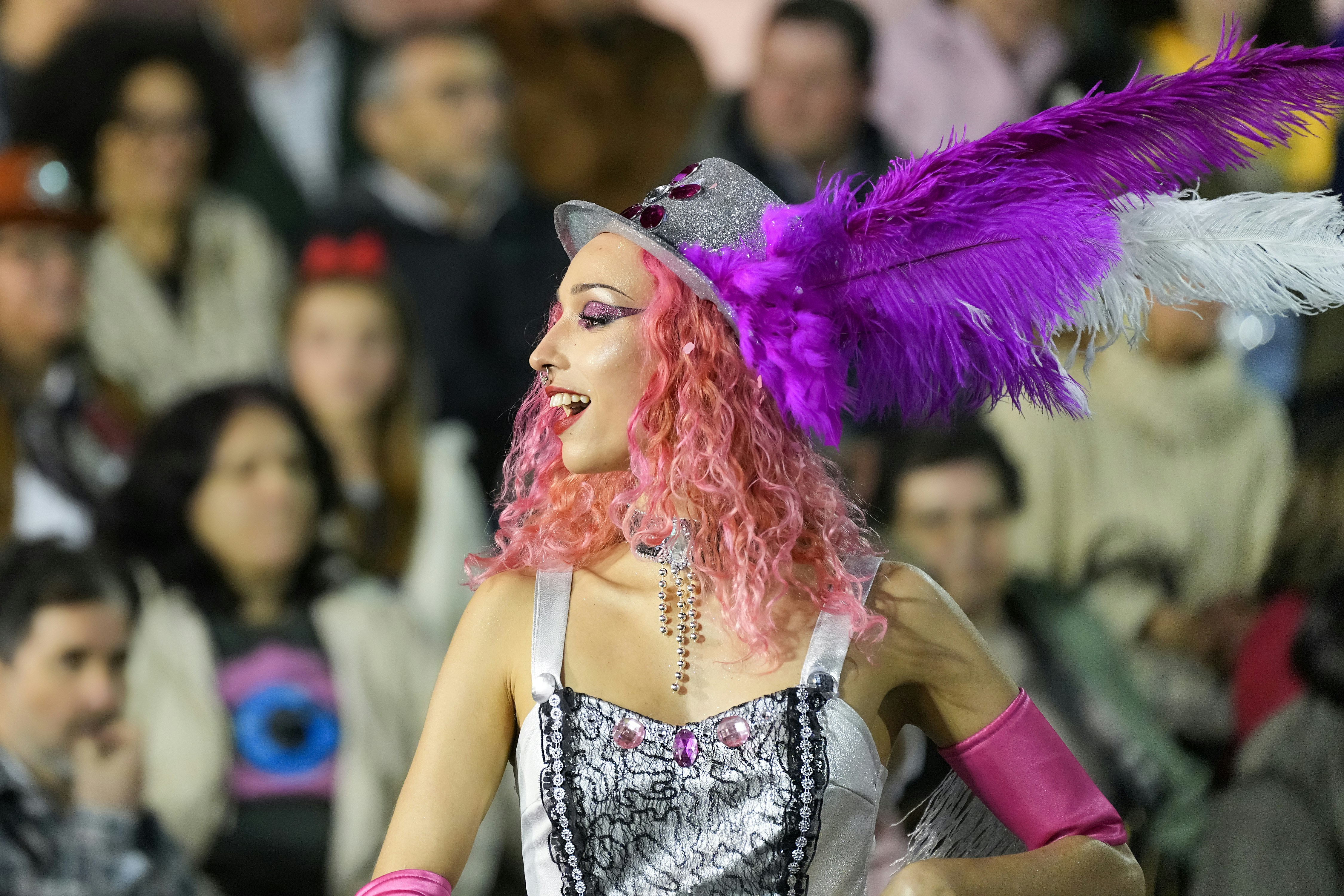 A woman in a costume smiles at a parade.
