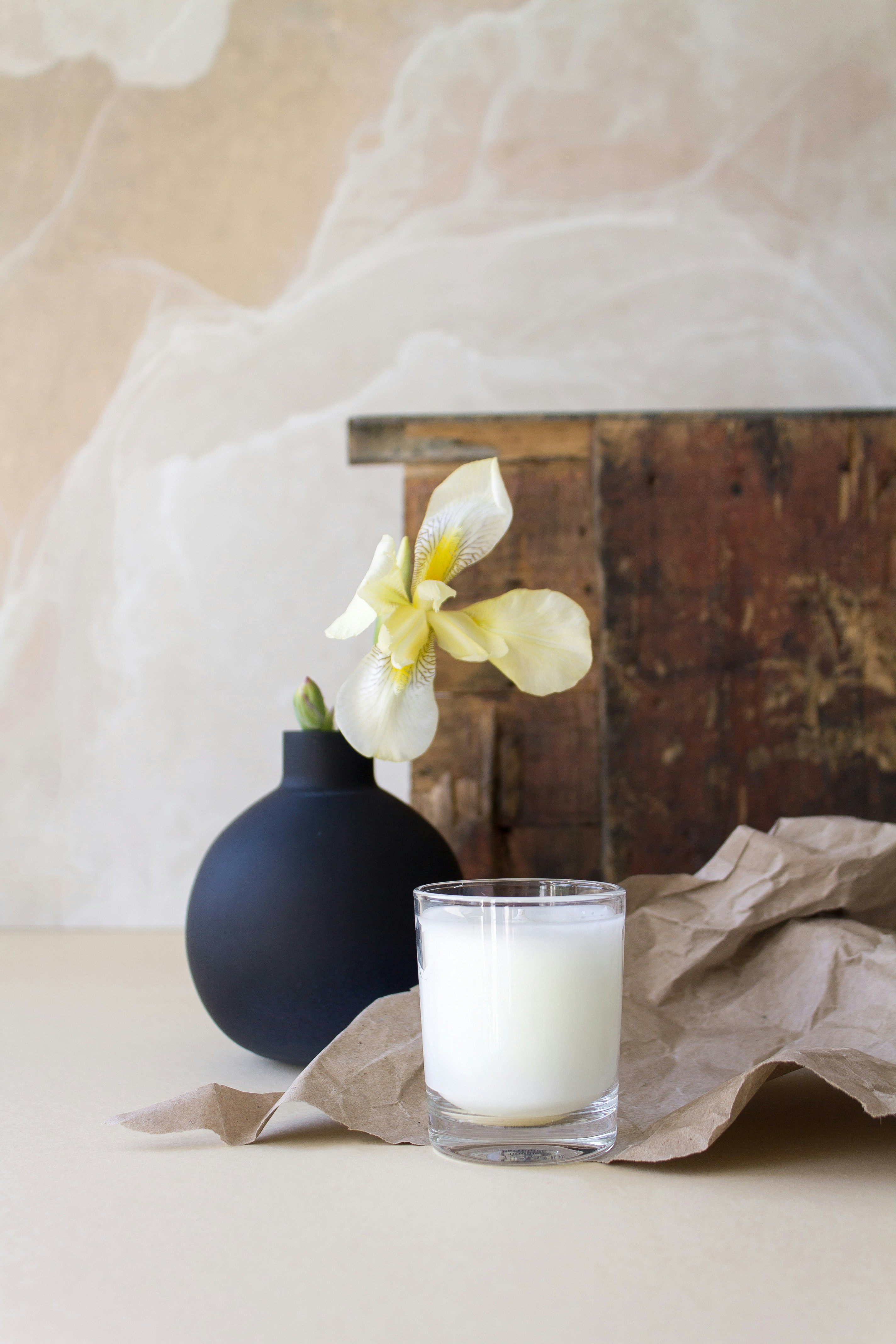 A flower, candle, and vase composition.