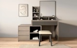 A modern vanity with a mirror and stool.