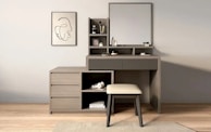 A modern vanity with a mirror and stool.