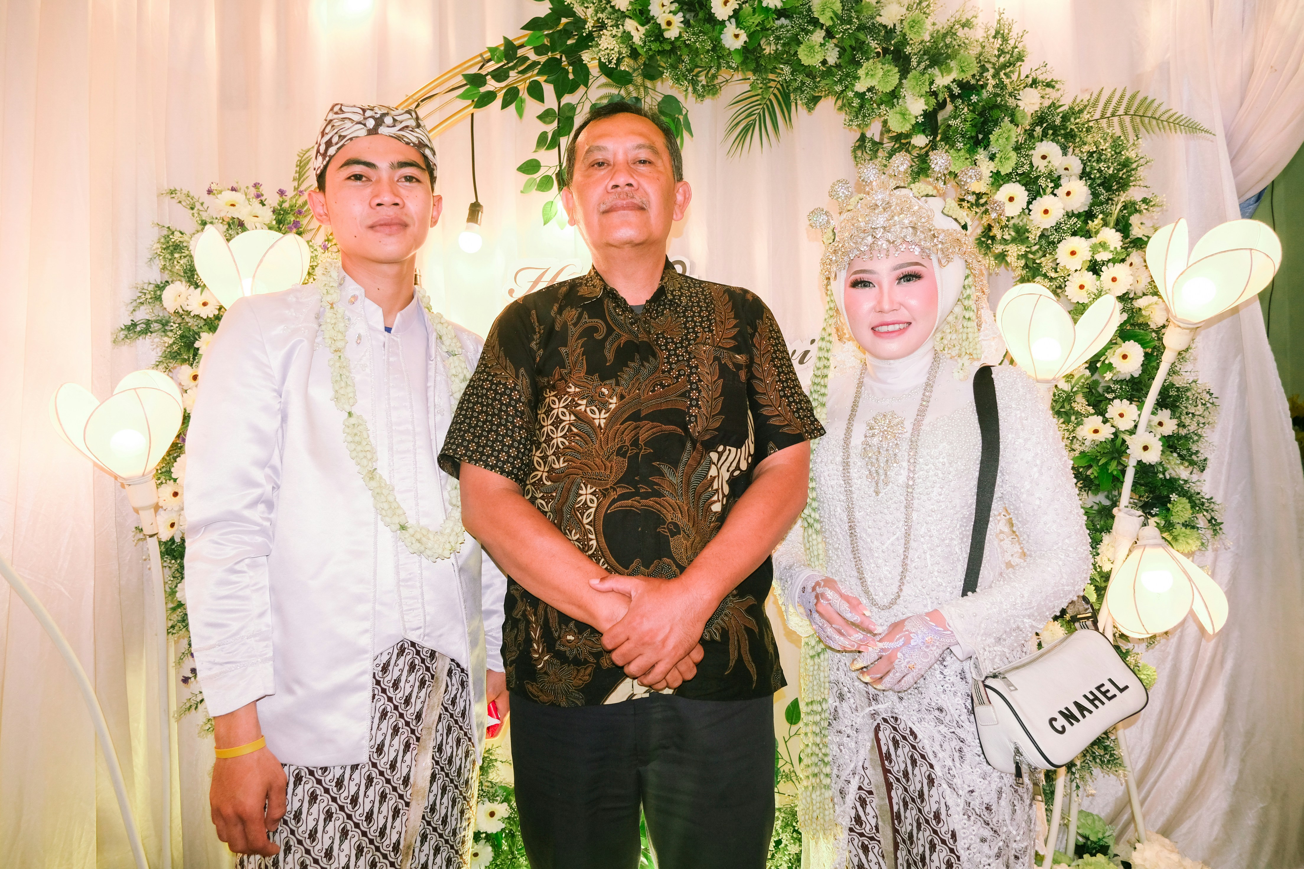 Sekelompok orang berpose untuk foto pernikahan.