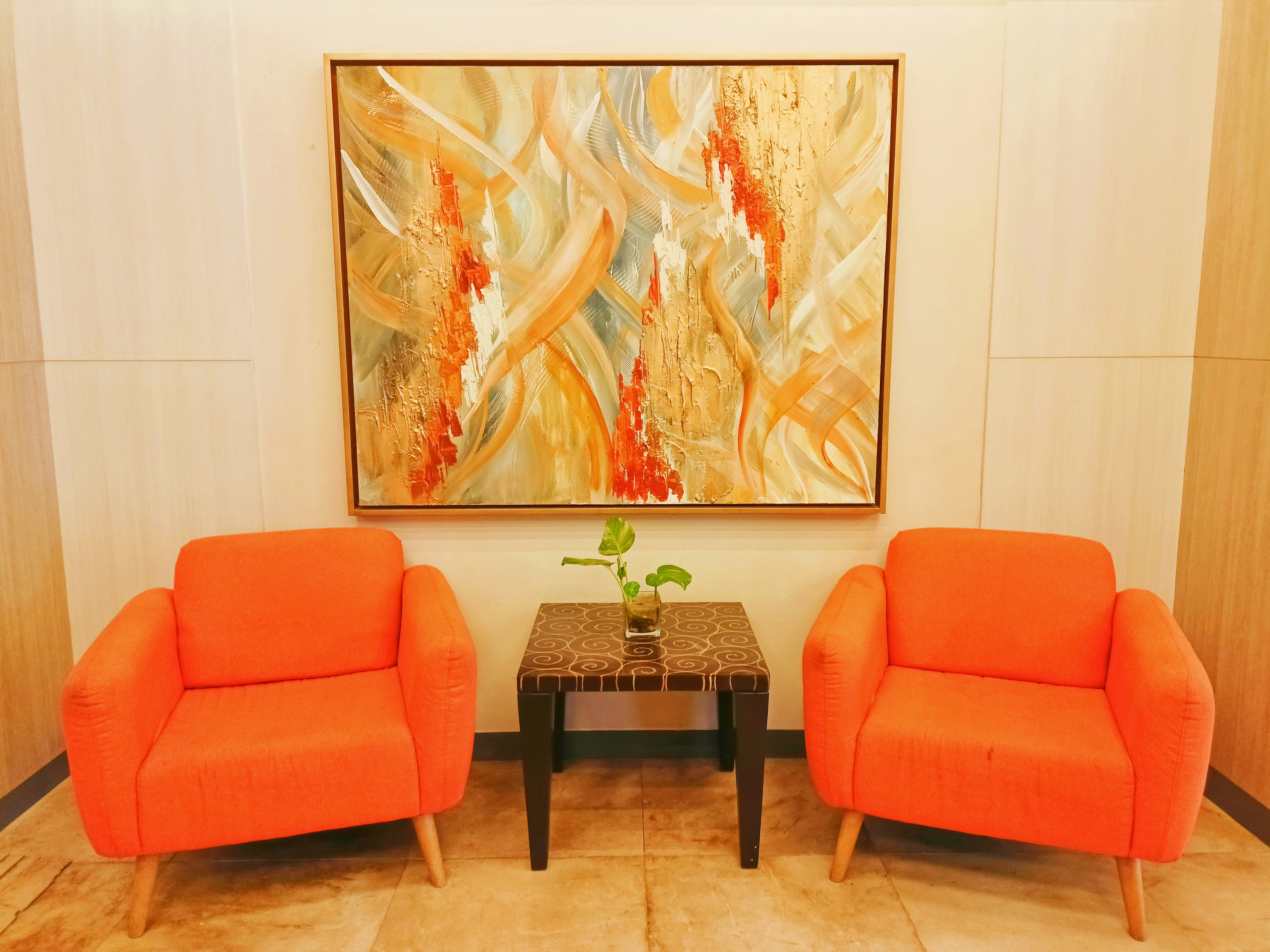 Orange chairs and wall painting in a hotel lobby