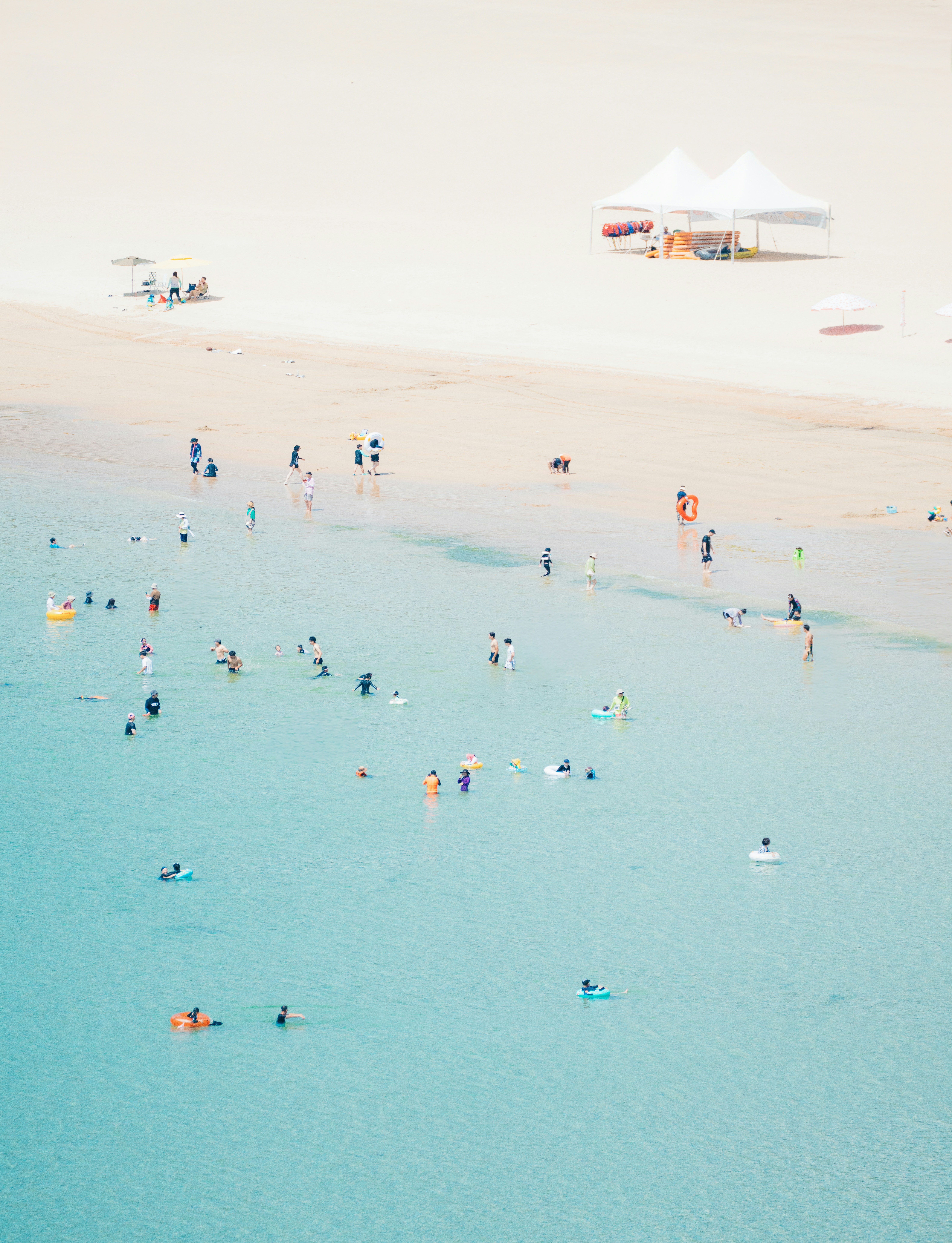 People swim in the turquoise ocean water.