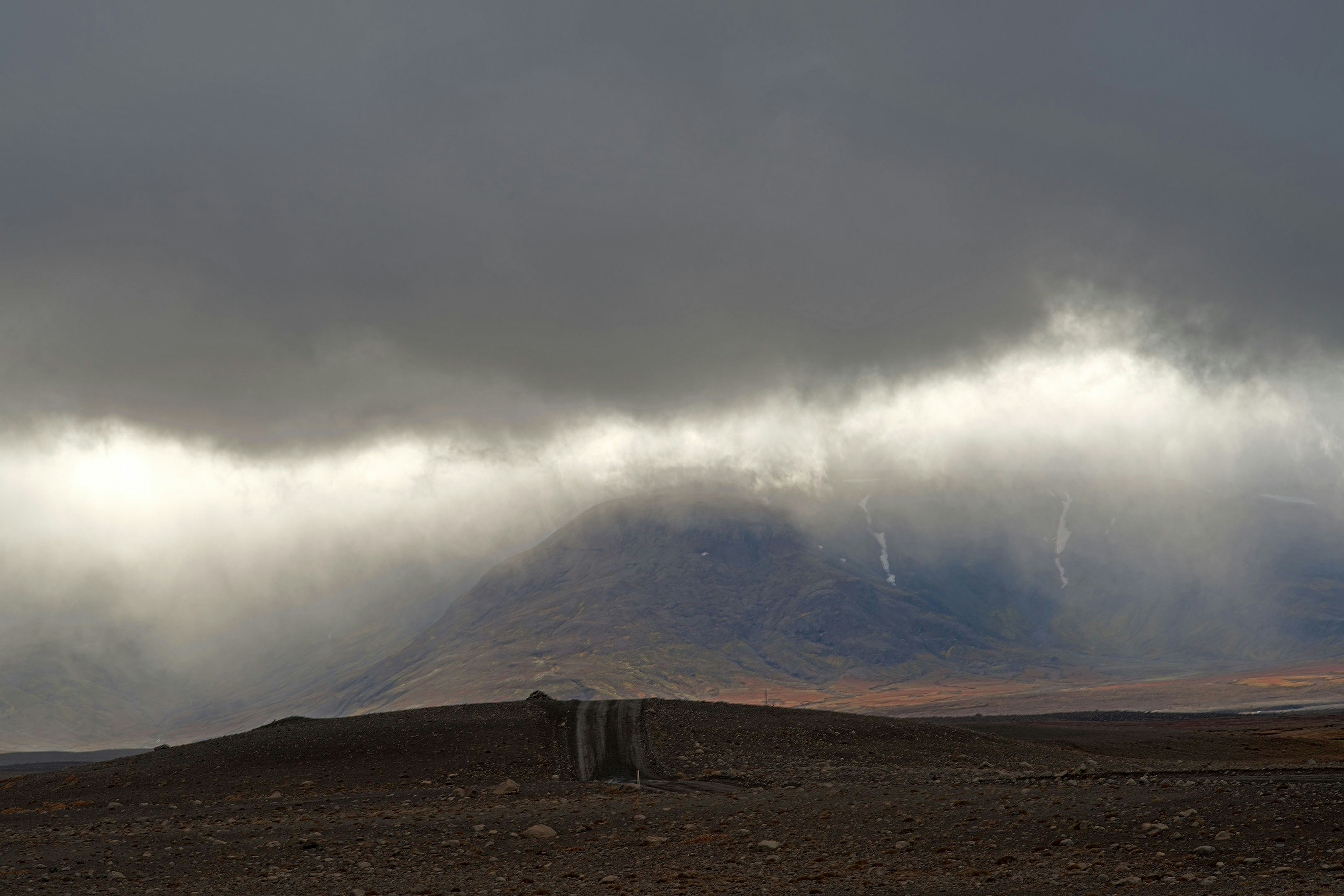 Mountains are shrouded in low, dark clouds.