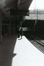 A person waits on a train platform.