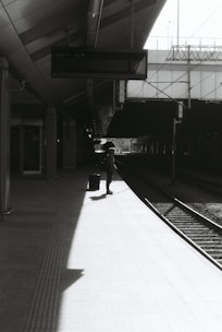 A person waits on a train platform.