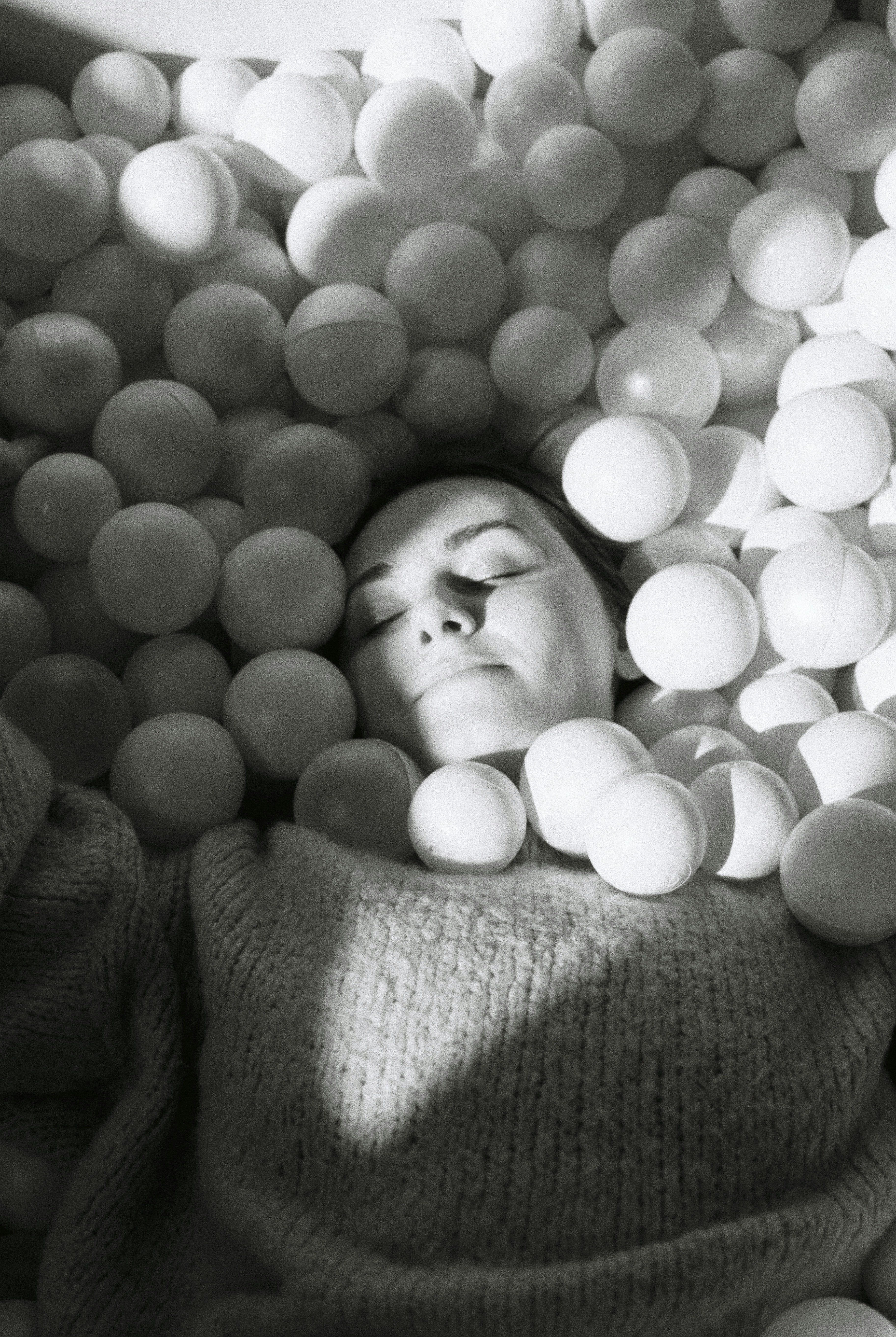 A woman is relaxing in a ball pit.