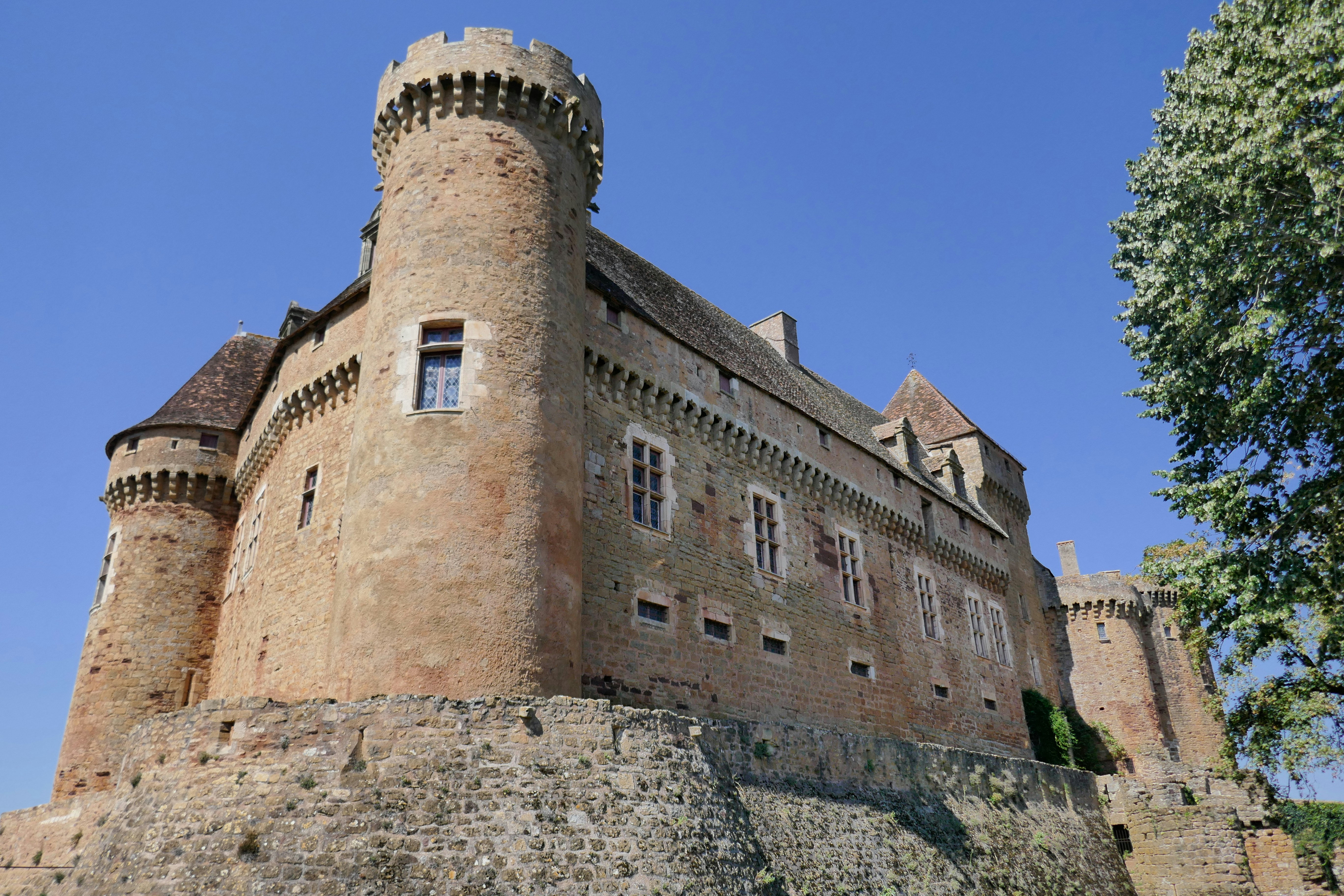 A stone castle stands tall against a clear sky.
