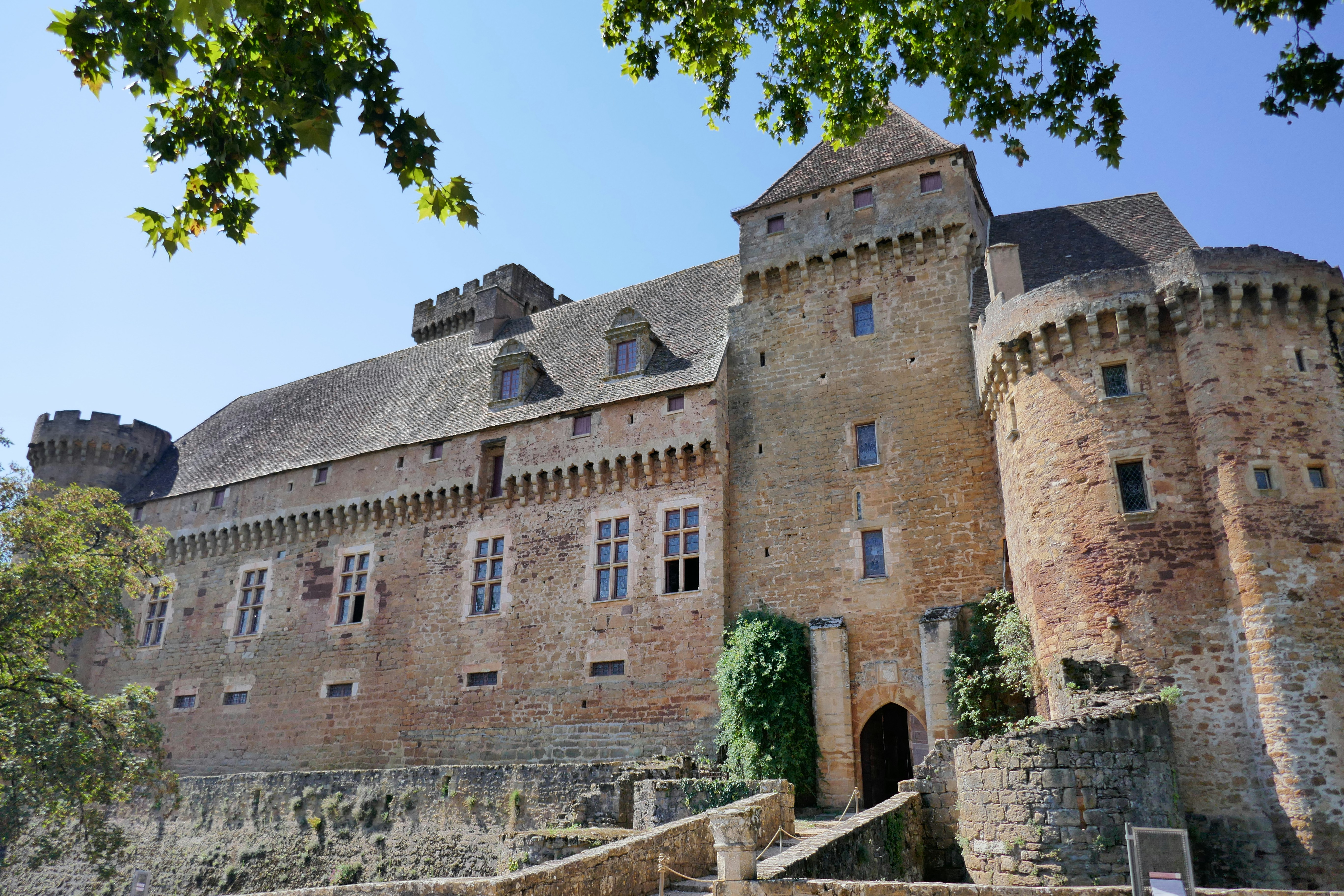 An old castle stands under a bright blue sky.