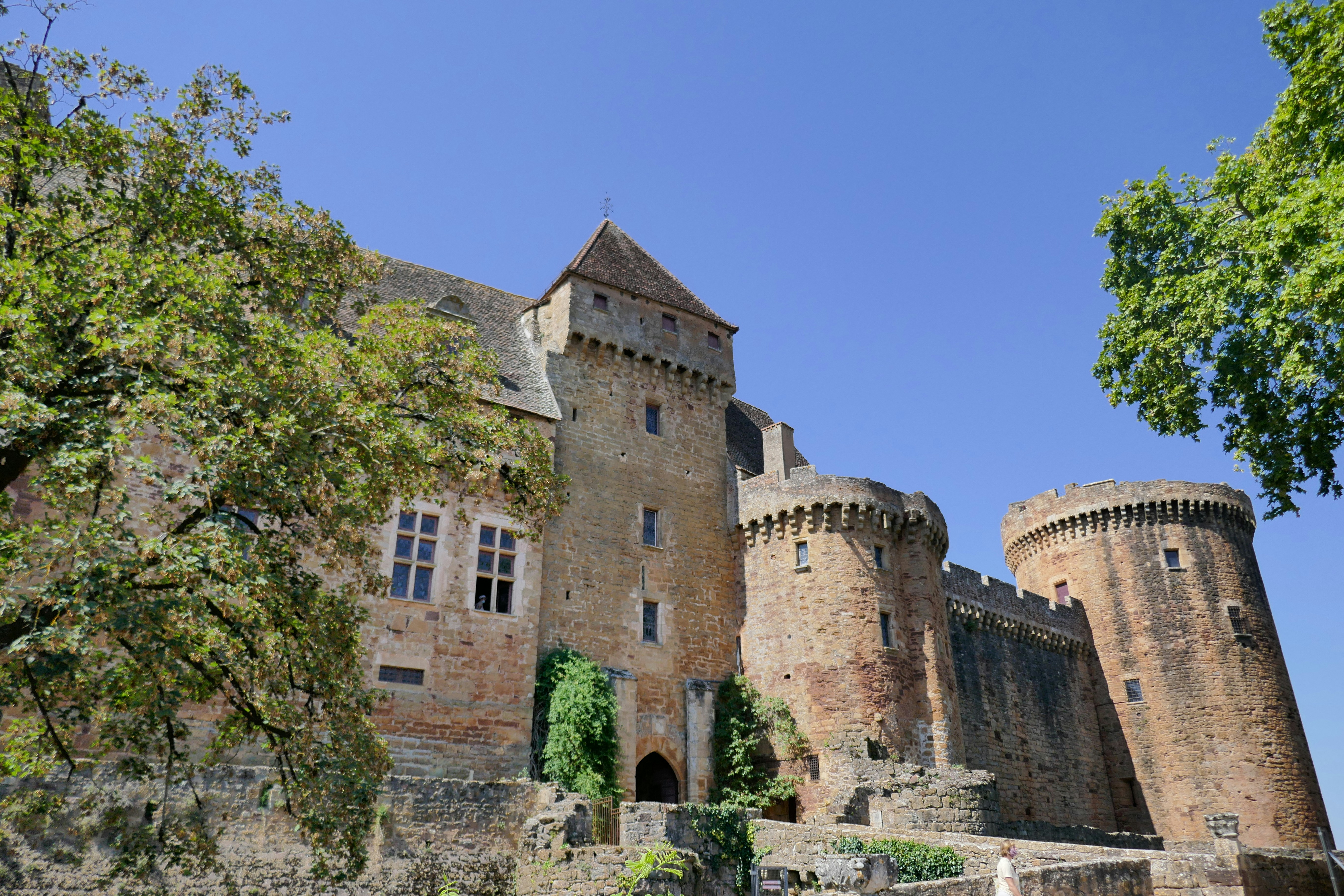 A majestic castle towers against a clear blue sky.