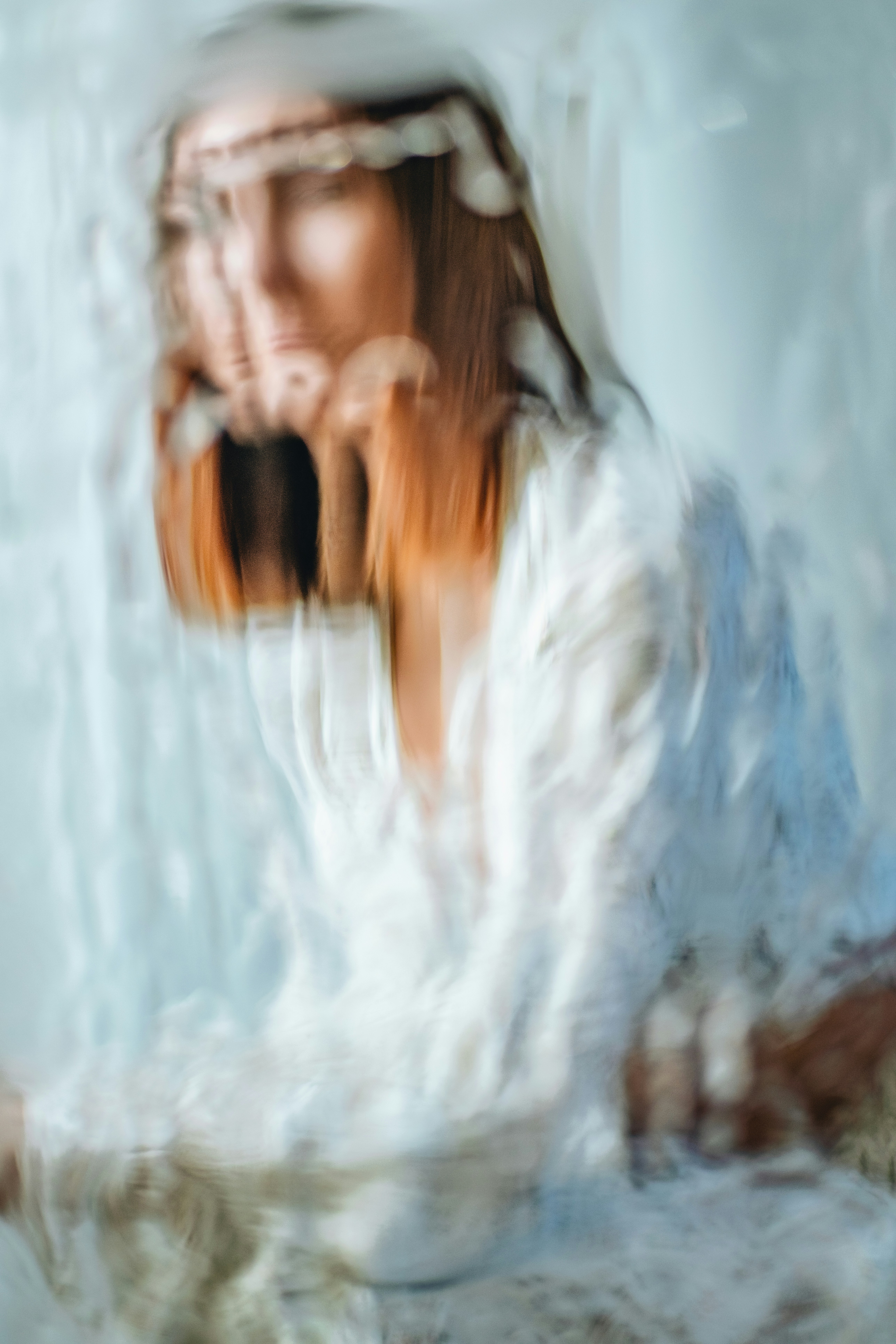 Woman in white dress seen through water.
