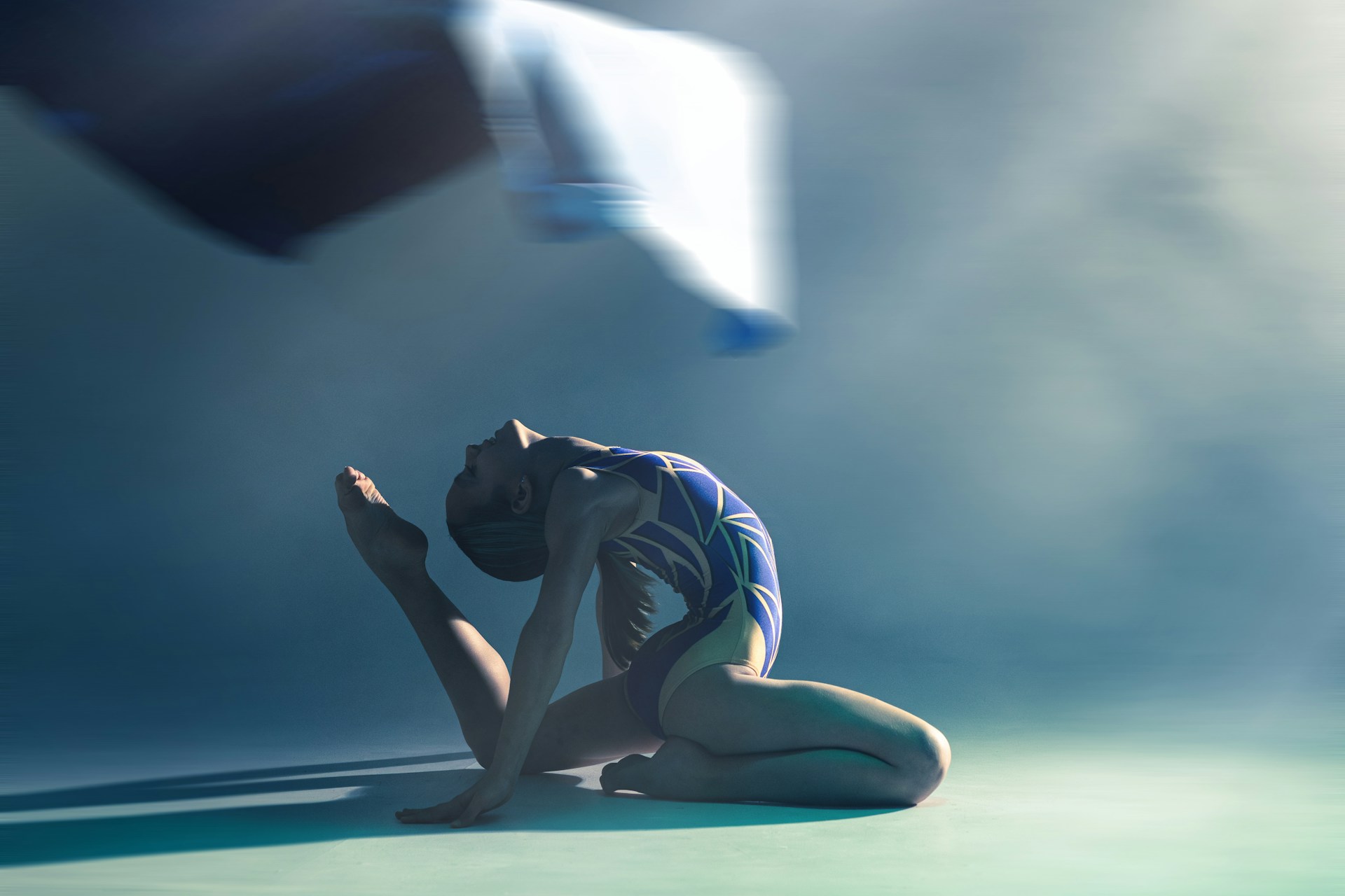 A gymnast performs a graceful, artistic pose.