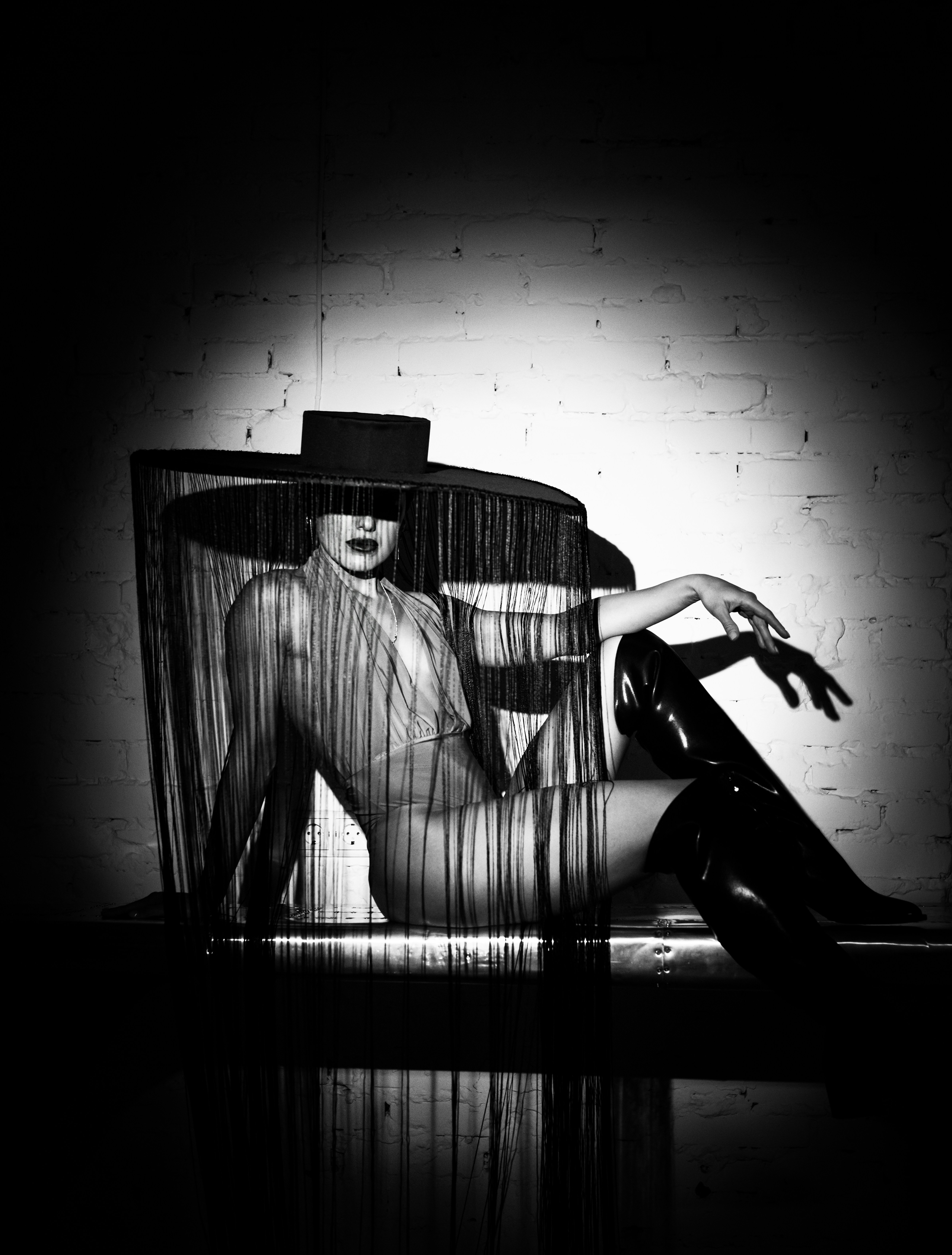 Femme élégante en chapeau et bottes pose gracieusement.