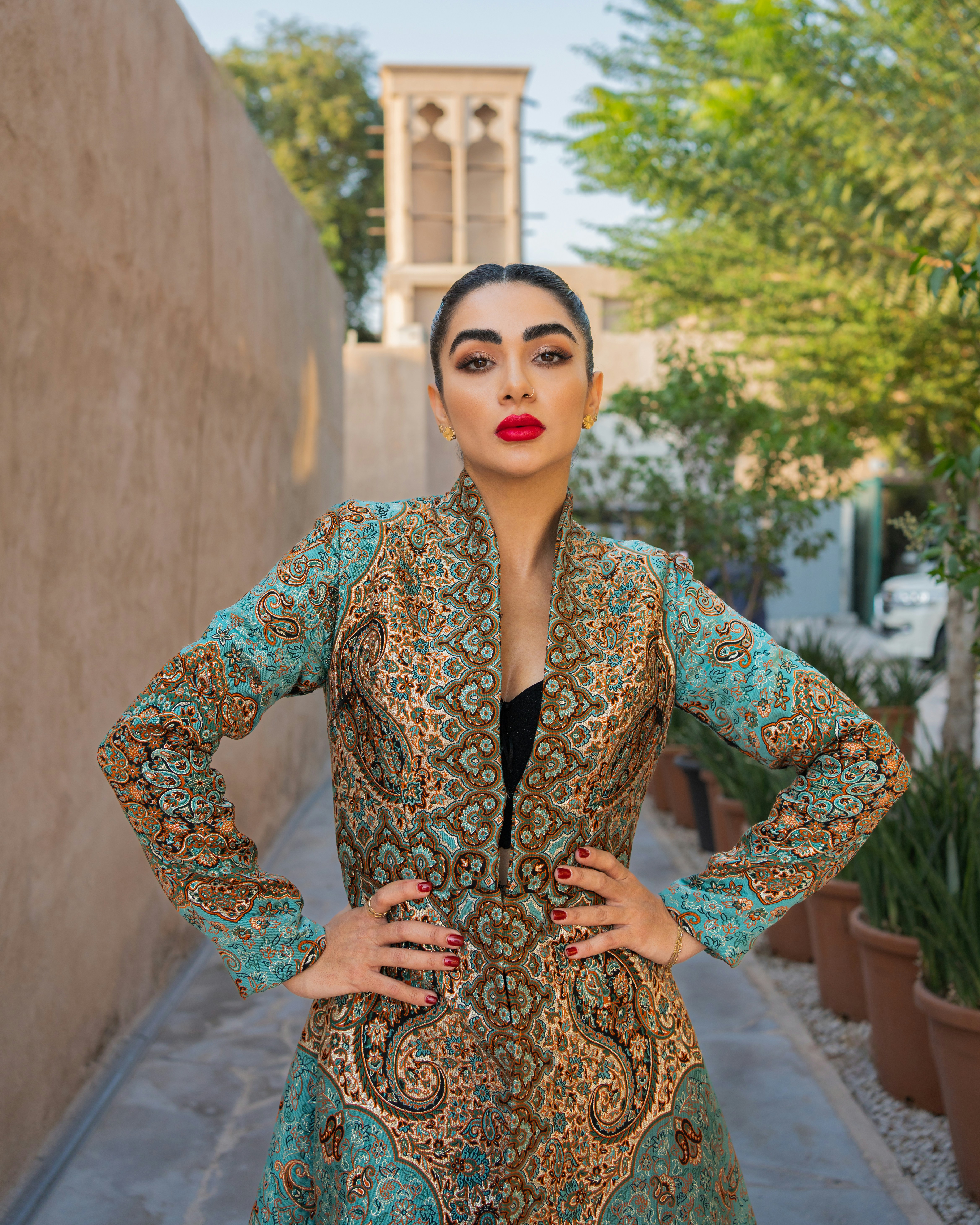 Hermosa mujer posa con un abrigo adornado y estampado.